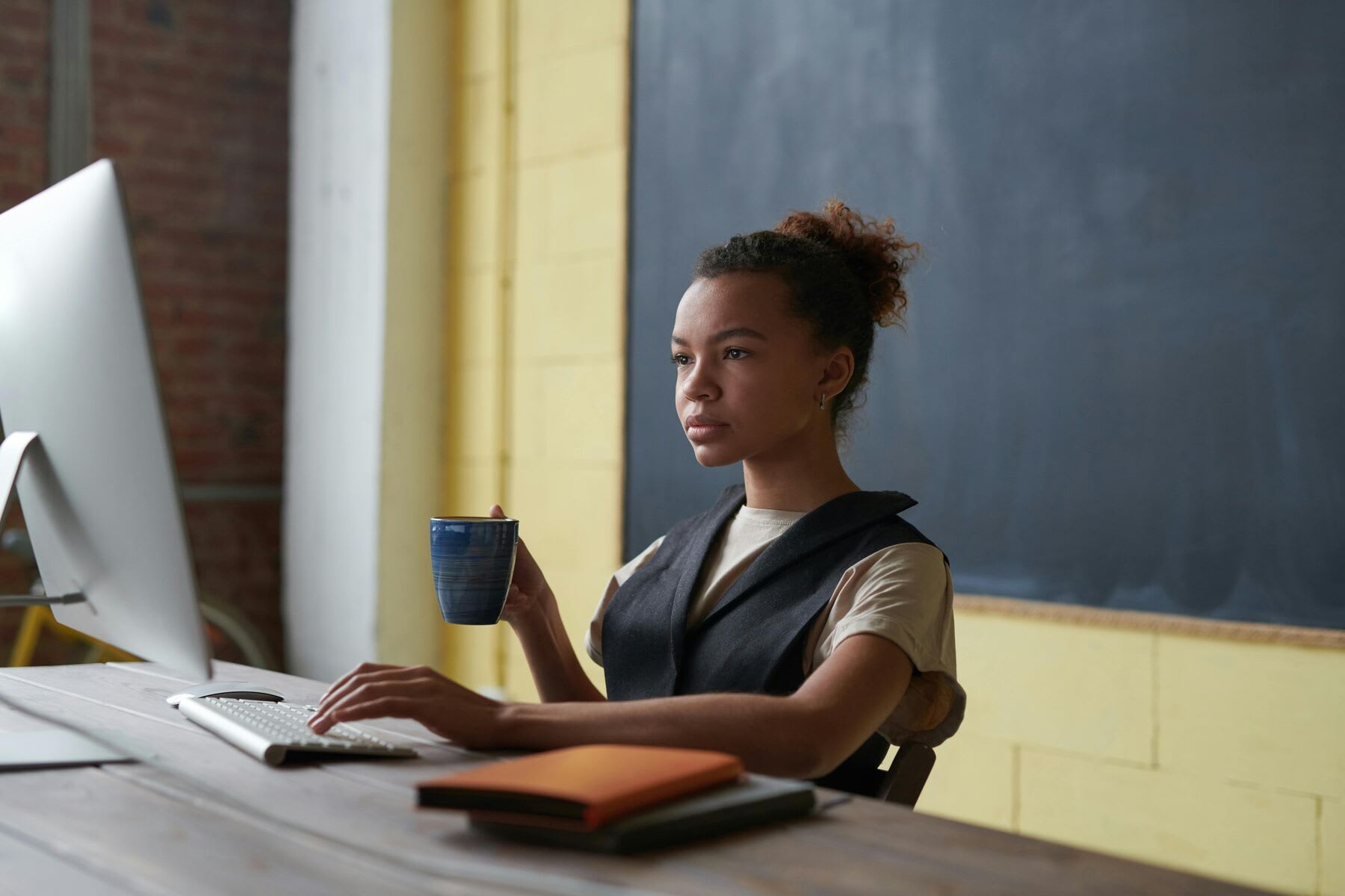 A woman having a cup of coffee while studying online