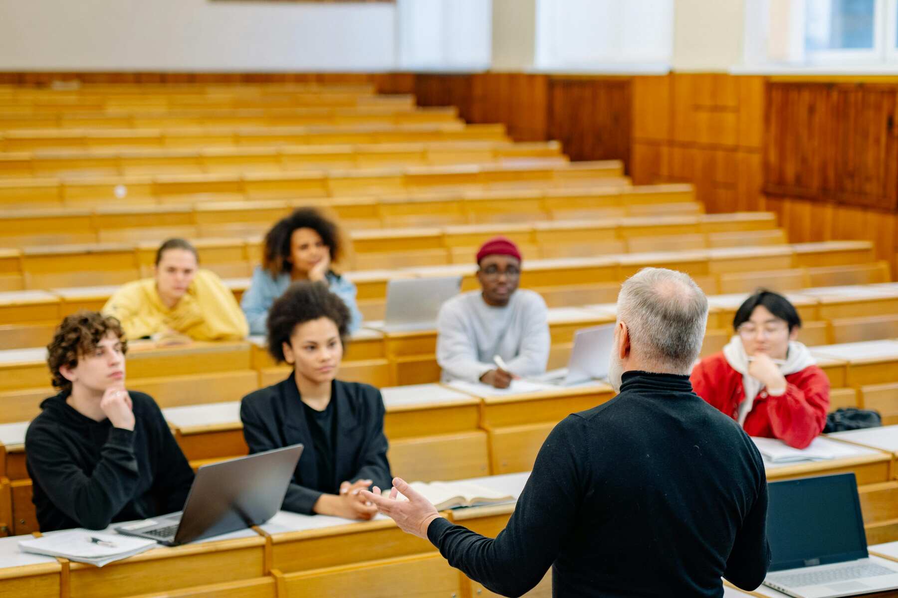 A professor teaching in front of a big room with small class