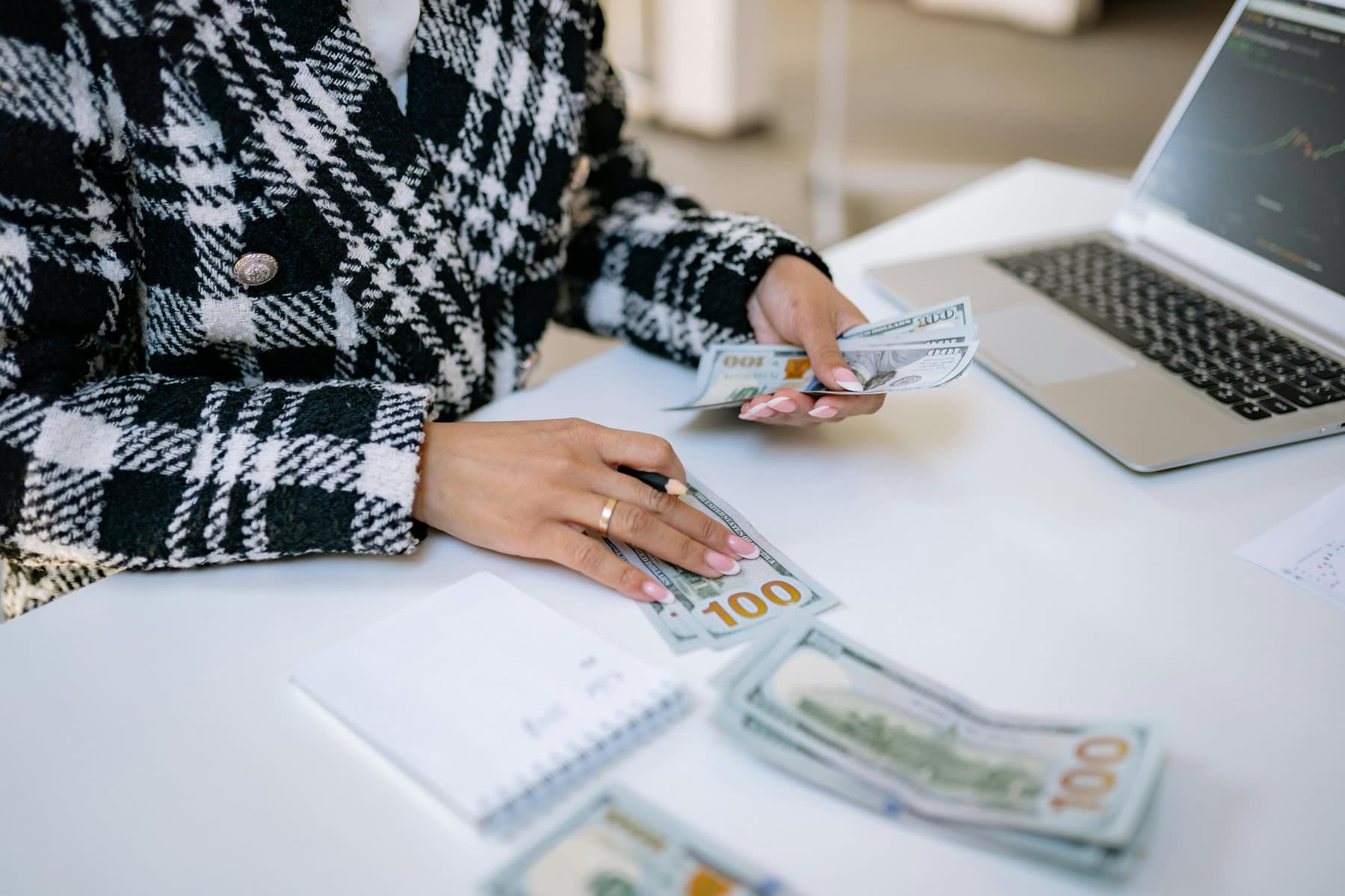 Woman counting 100 dollar bills