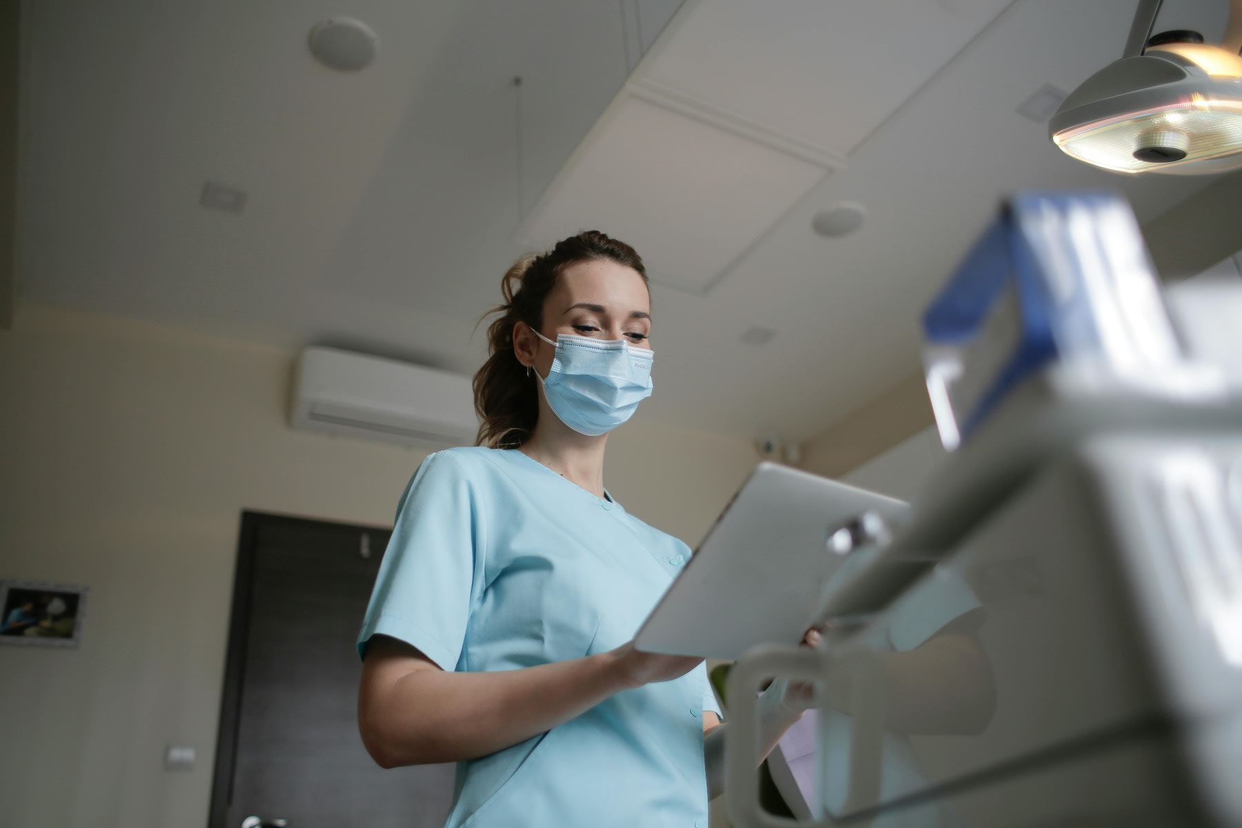 Nurse reading a tablet while wearing a mask