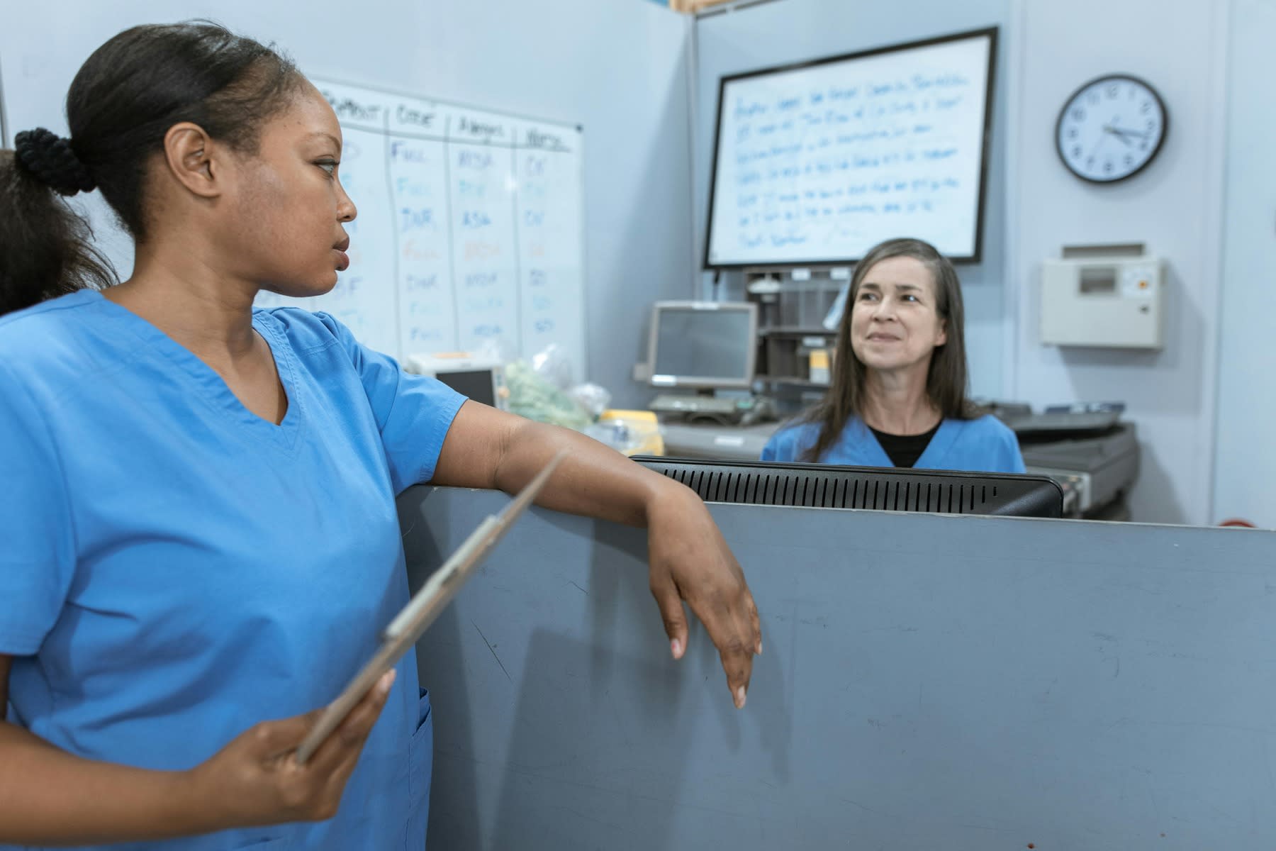 Two nurses talking at the information desk