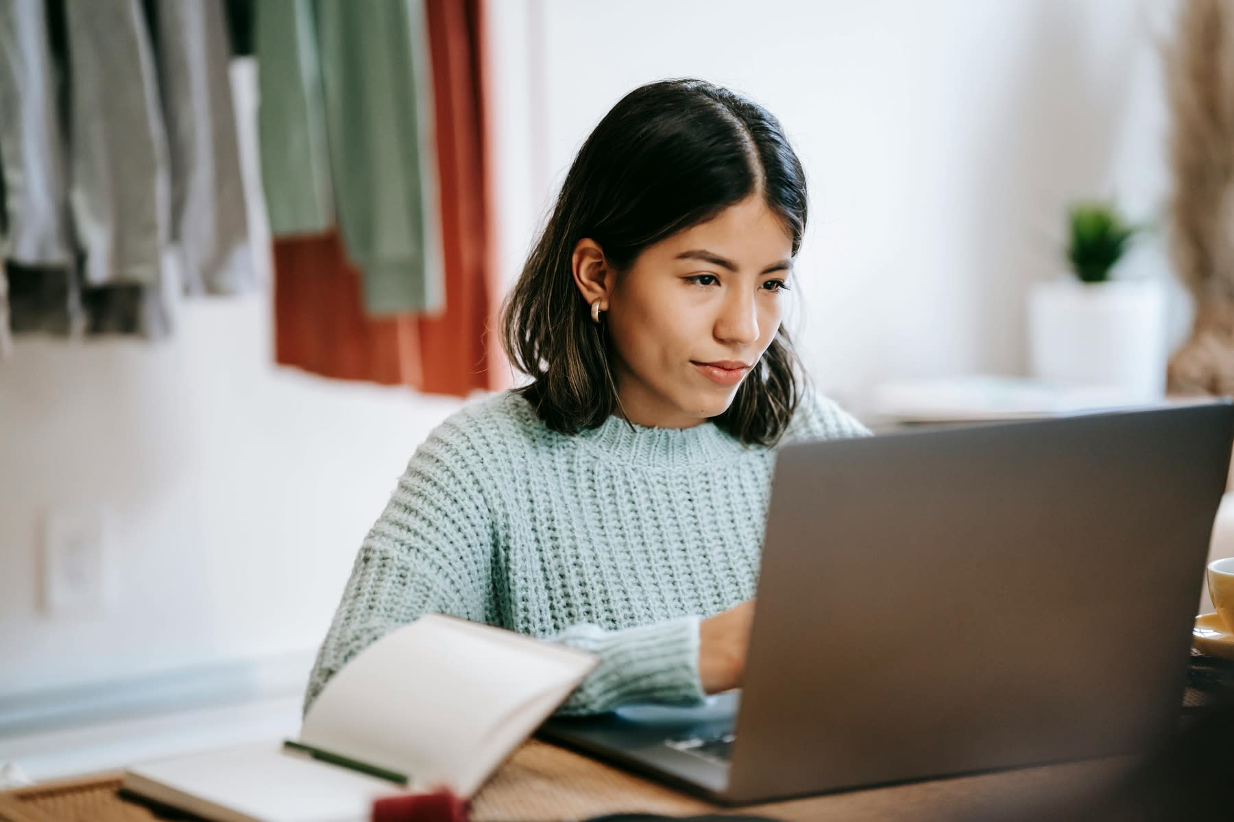 Woman using her laptop while seated on her desk