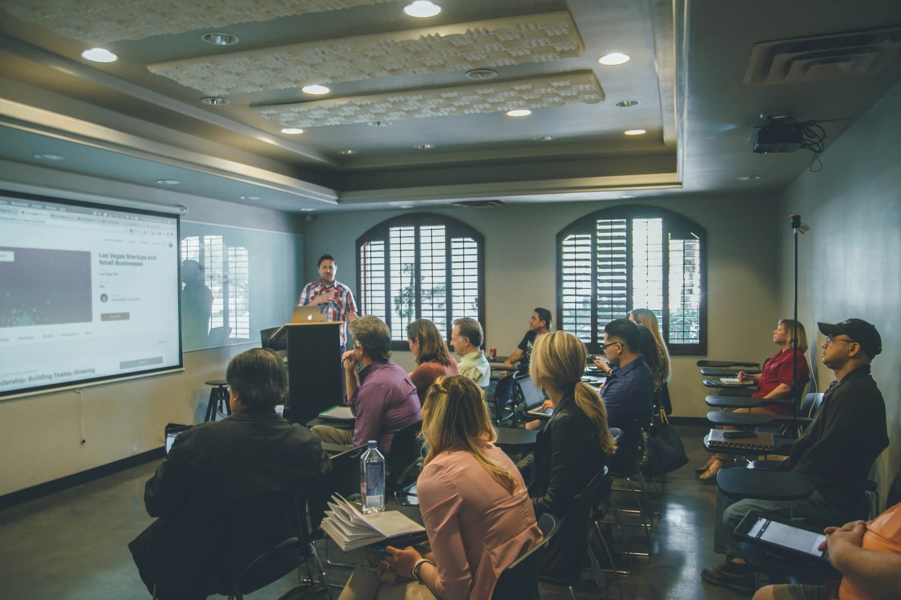 Professor teaching a class for adult students using a projector