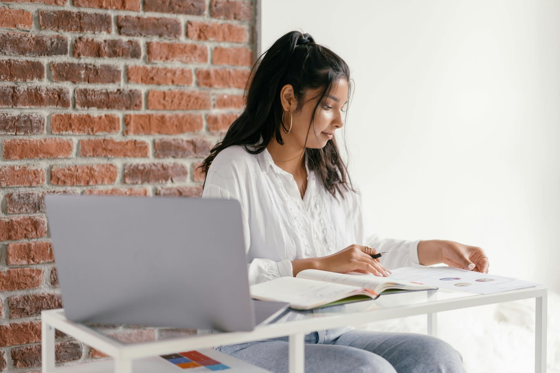 Woman reading a book while holding a pen with her hand