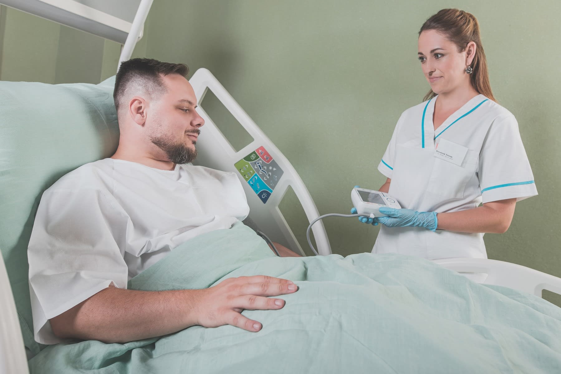 Nurse checking a patient's bed controls