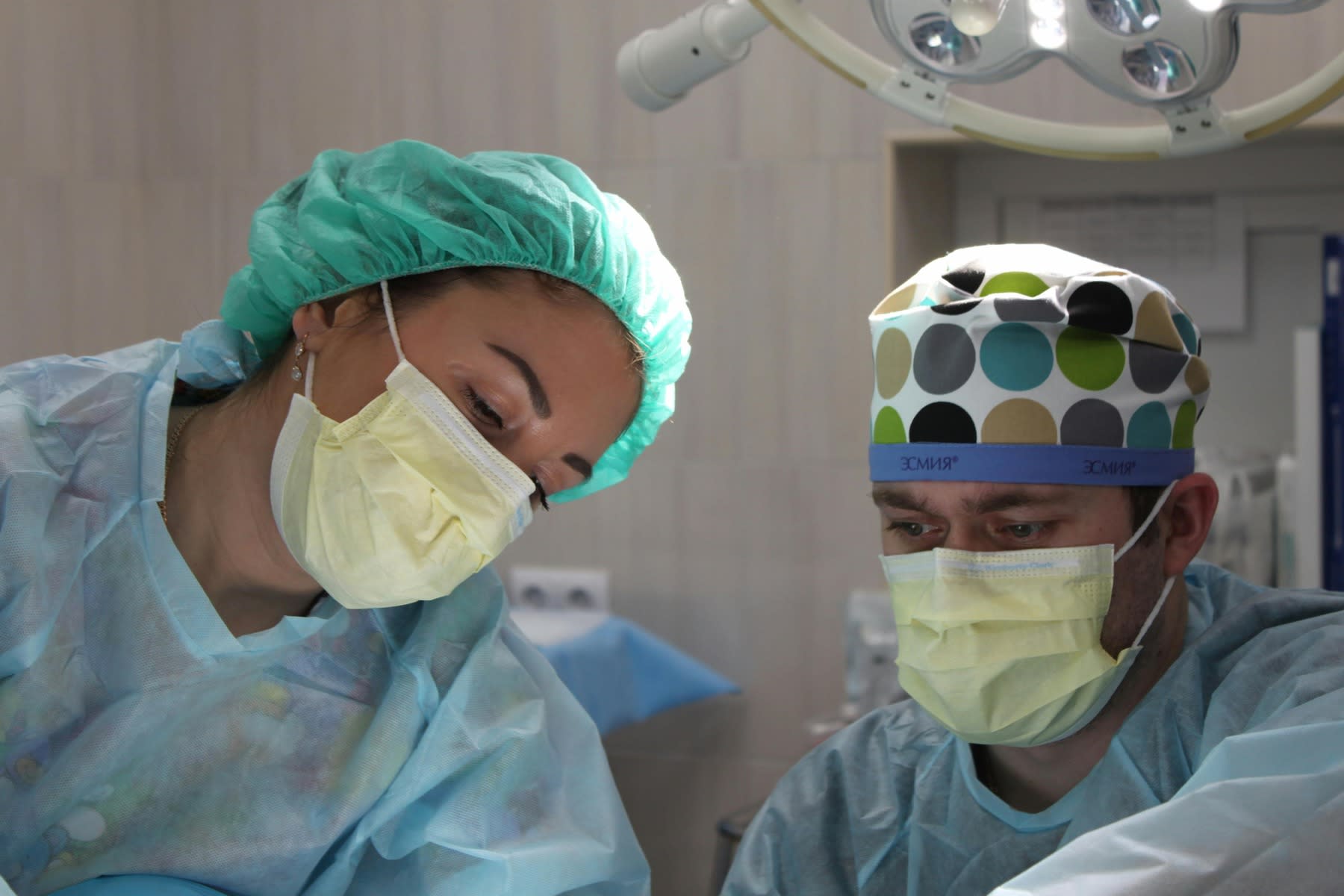 Two nurses wearing protective gear during an ongoing surgery