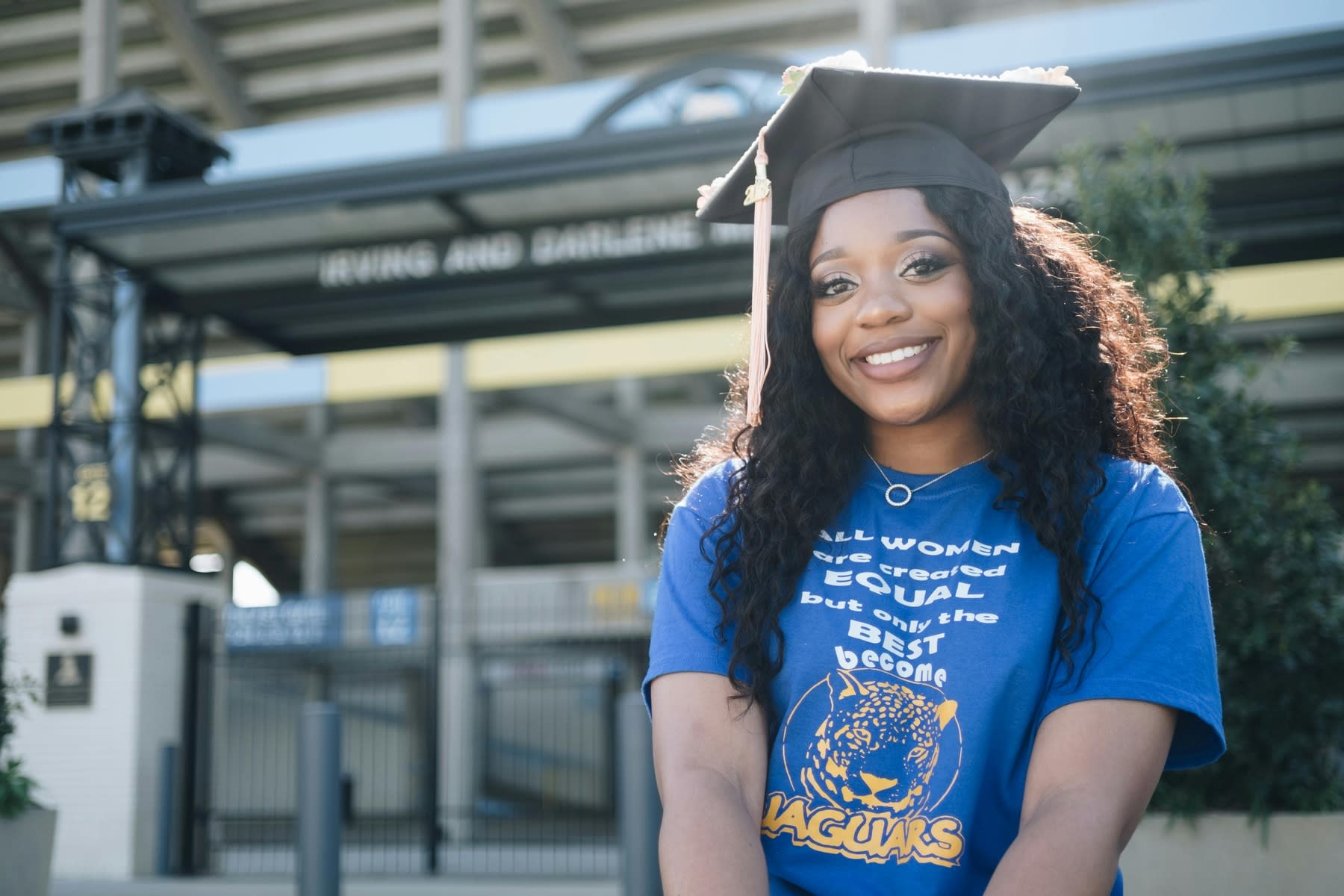 Woman wearing a graduation cap with a plain blue shirt