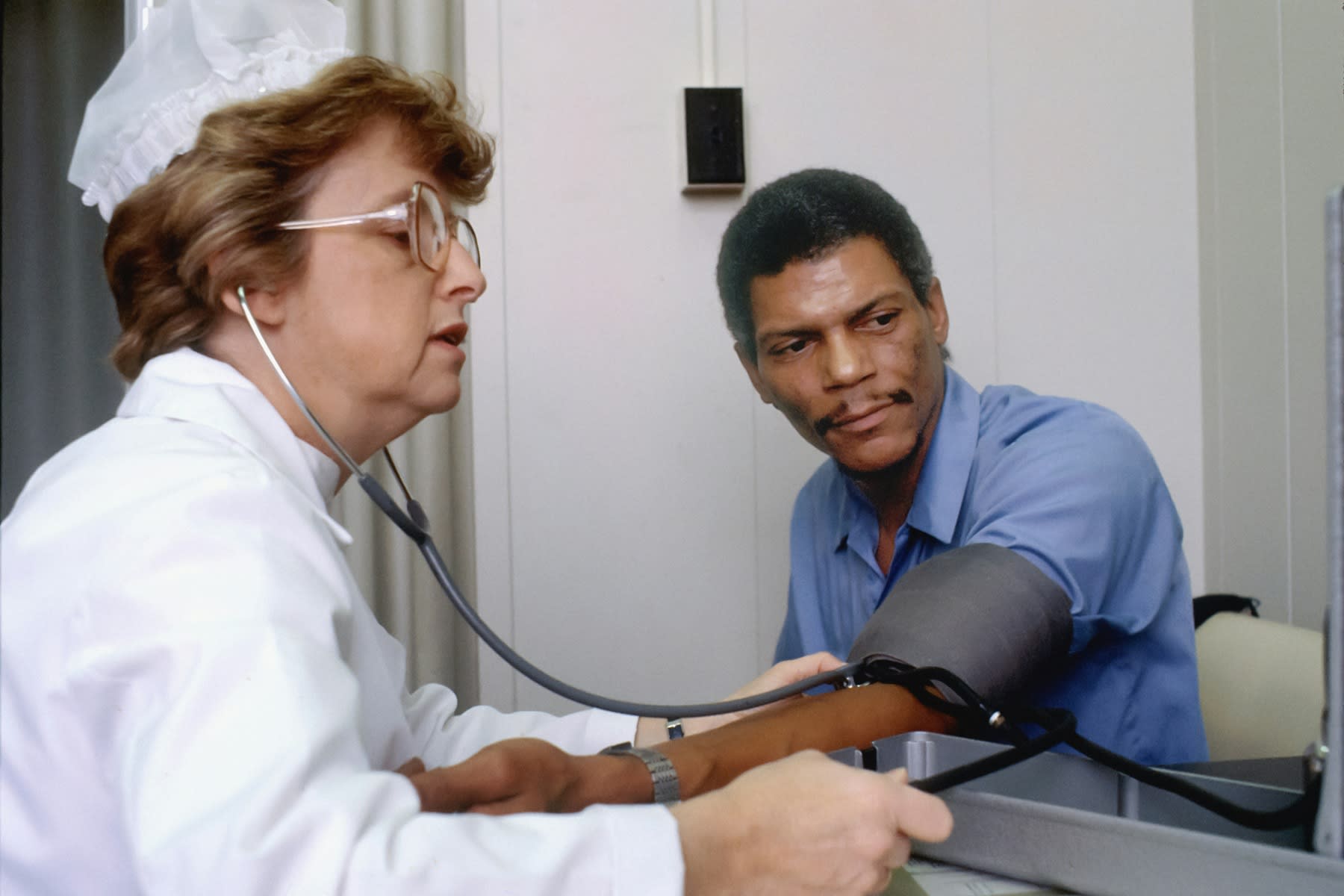 Female nurse checking the blood pressure of a male patient