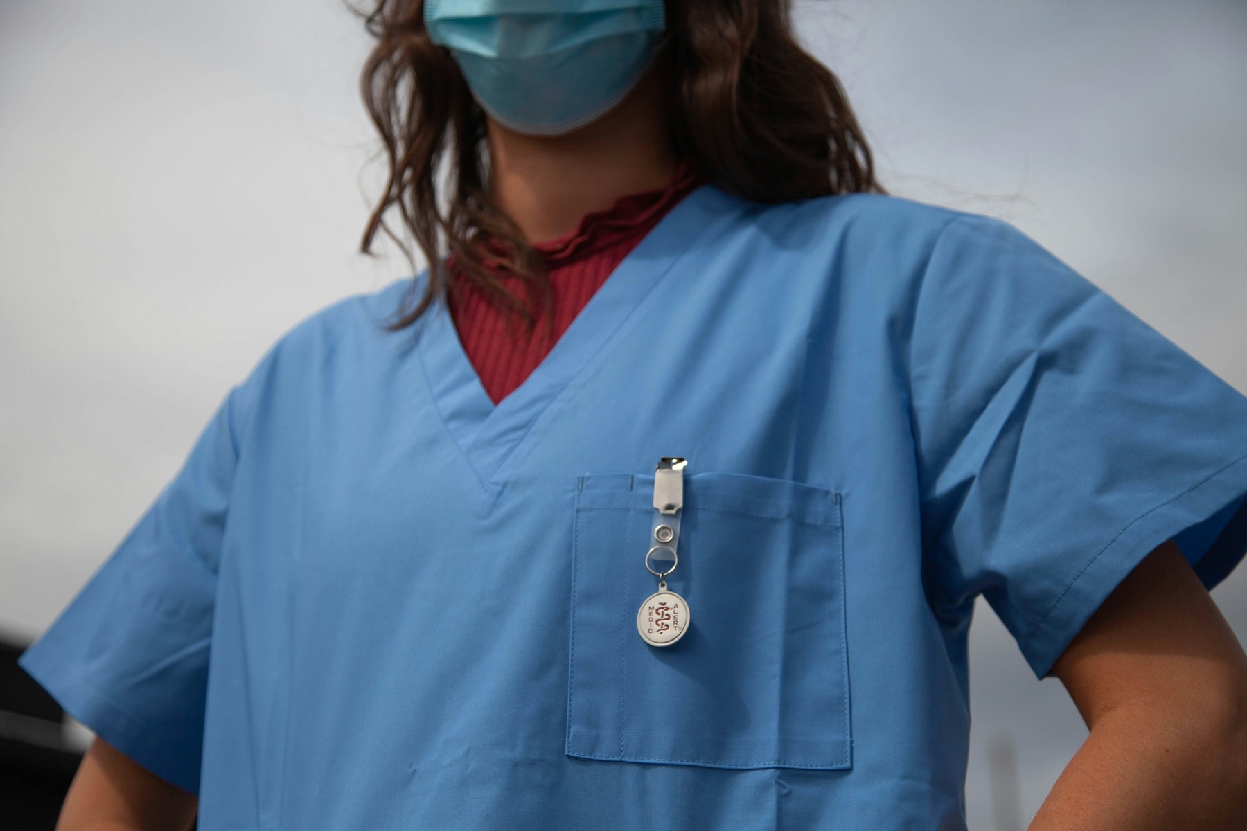 Woman wearing nursing scrubs and wearing a face mask