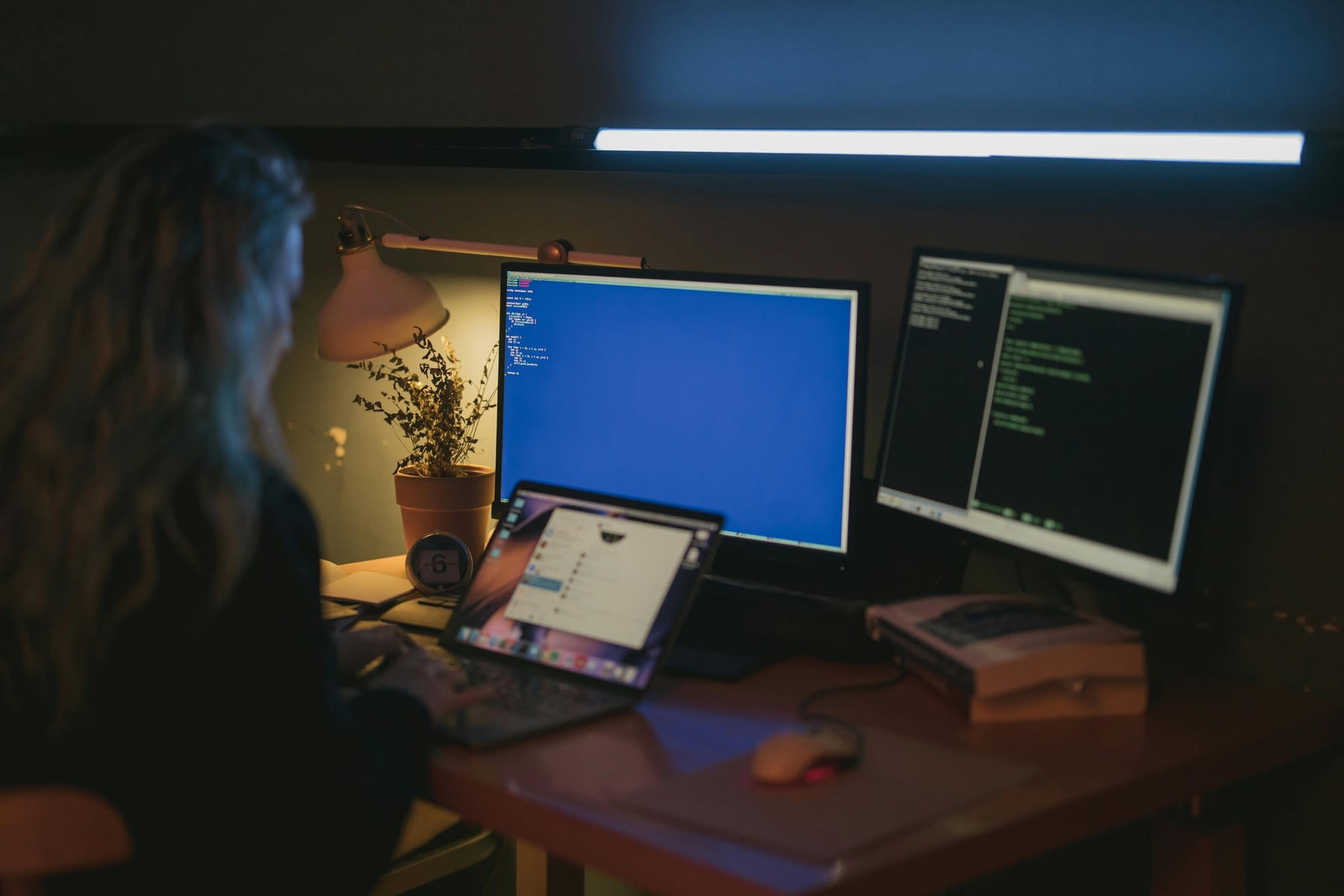 Woman using multiple monitors and computers for her work