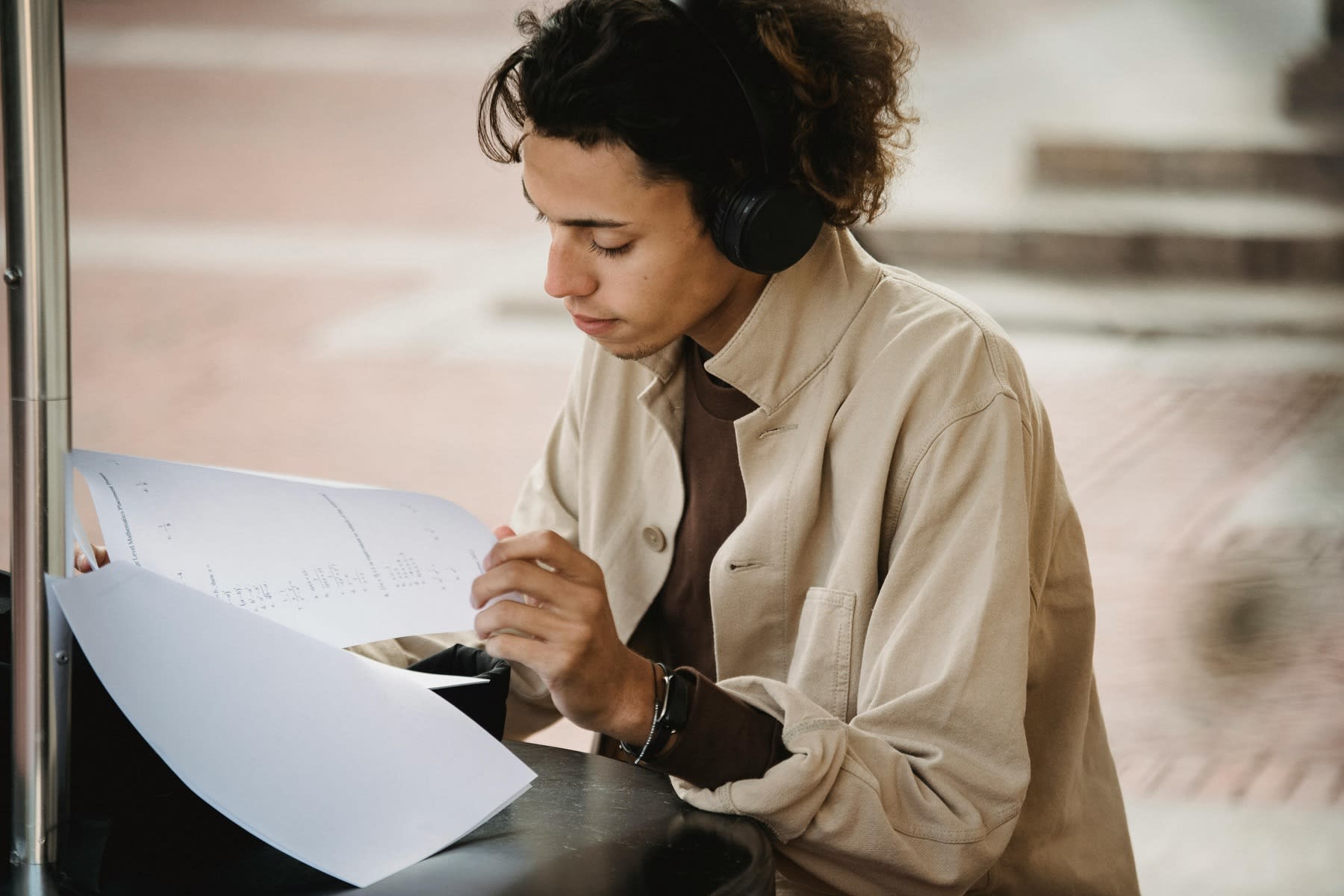 Young man checking and reading printed documents