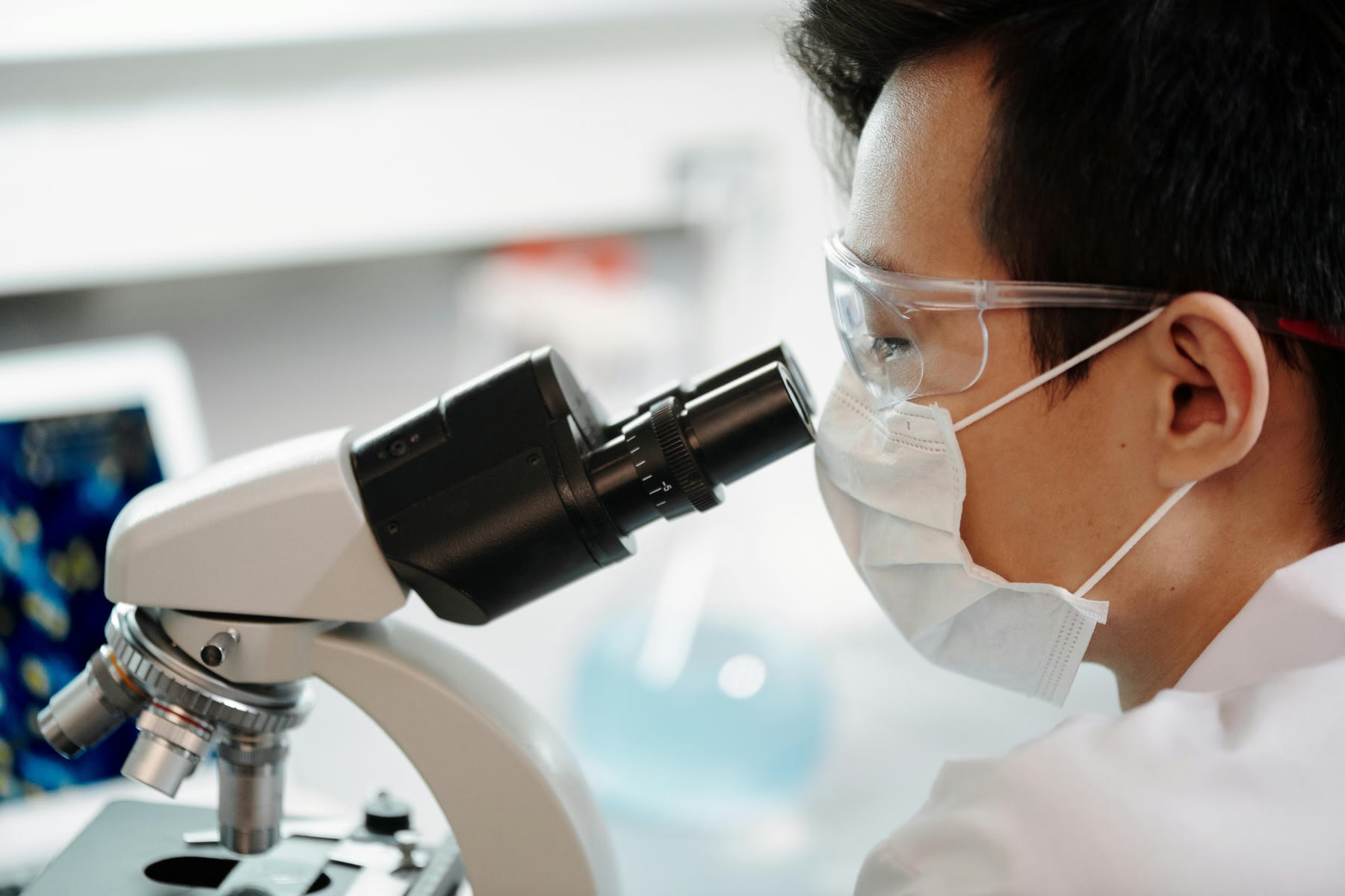 A biologist looking through the lens of a microscope