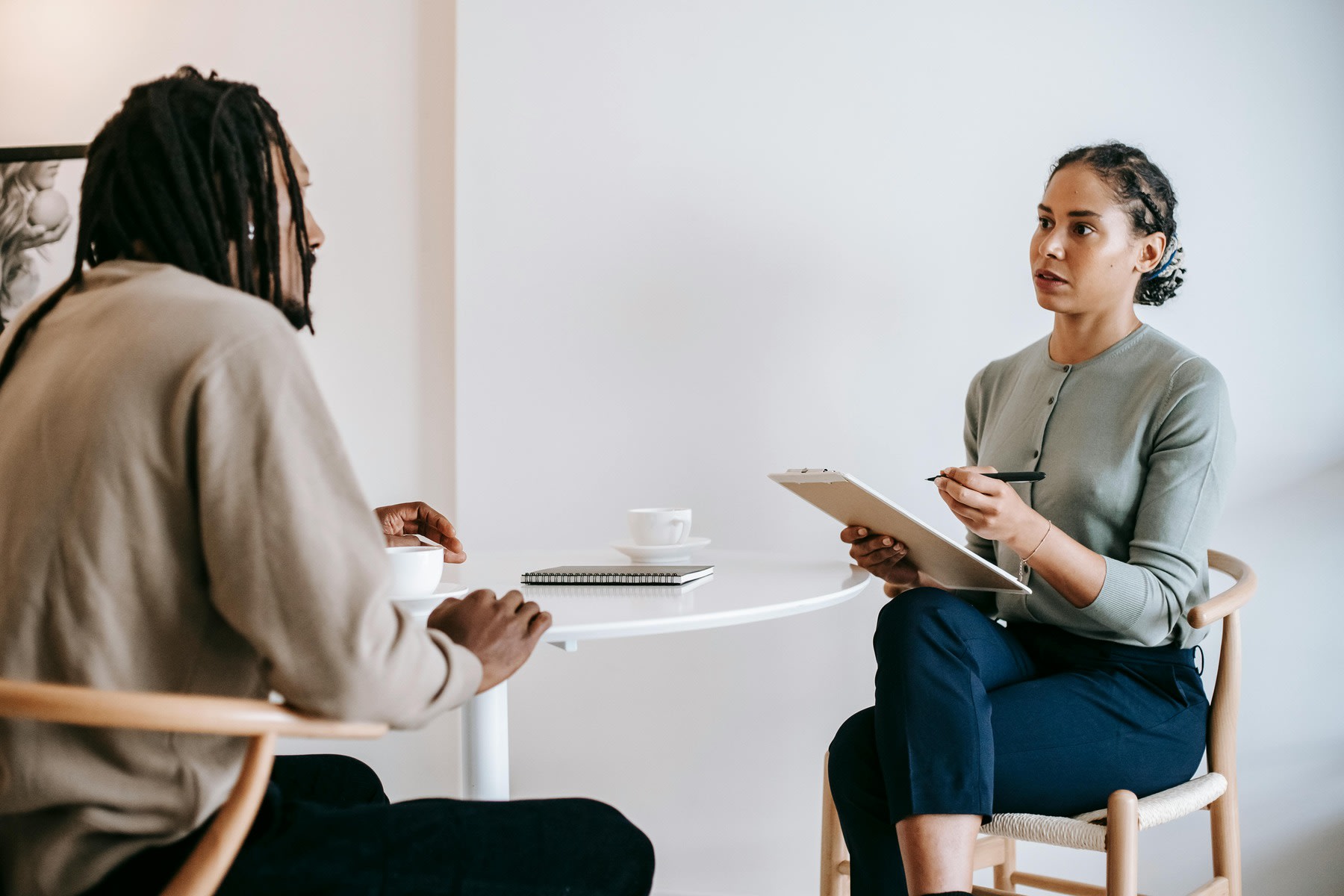 A psychologist talking to a man while taking notes