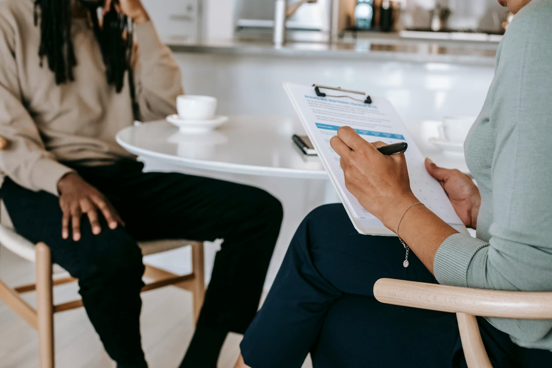 A woman taking notes while talking to her client