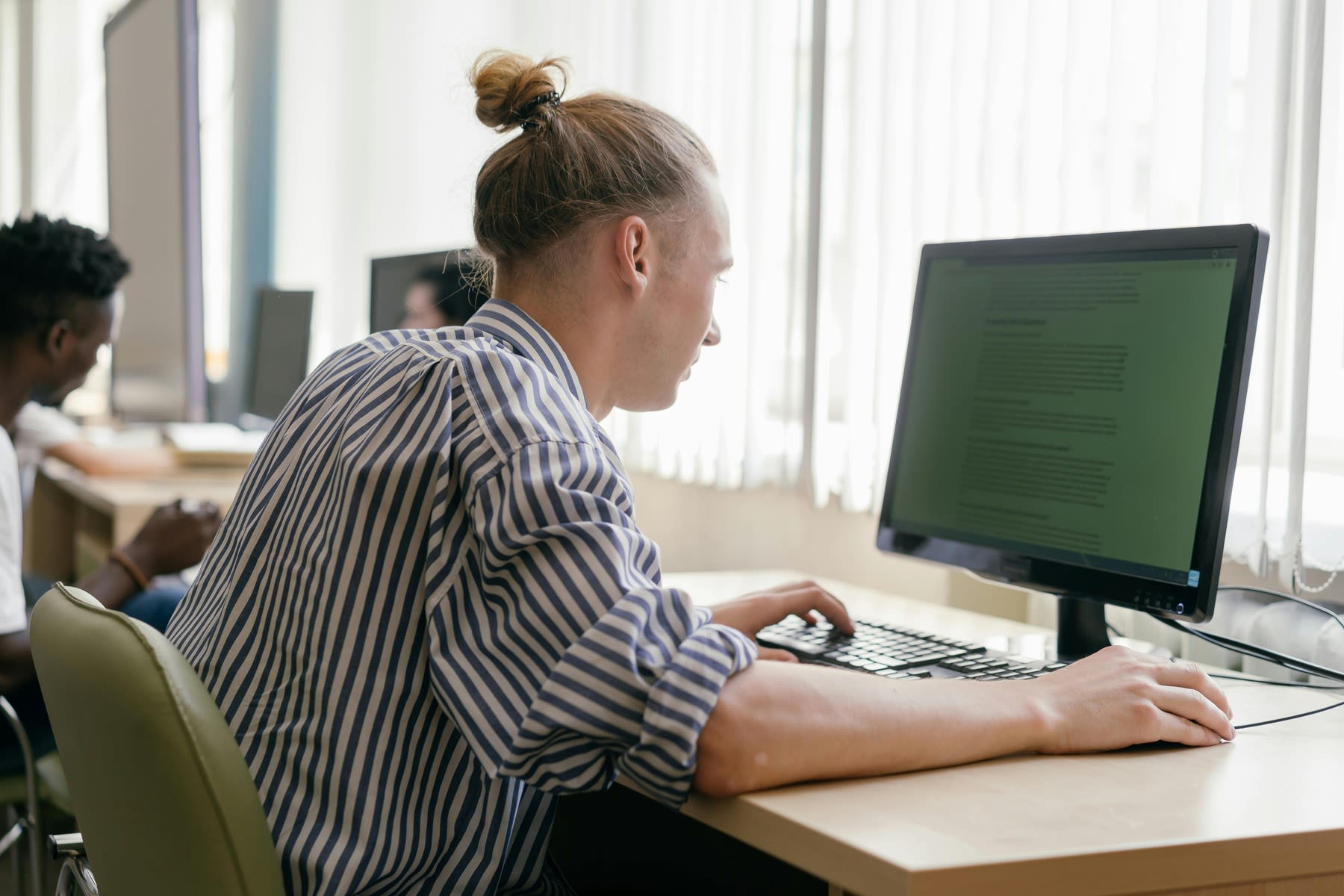 An adult in front of a PC while using the mouse