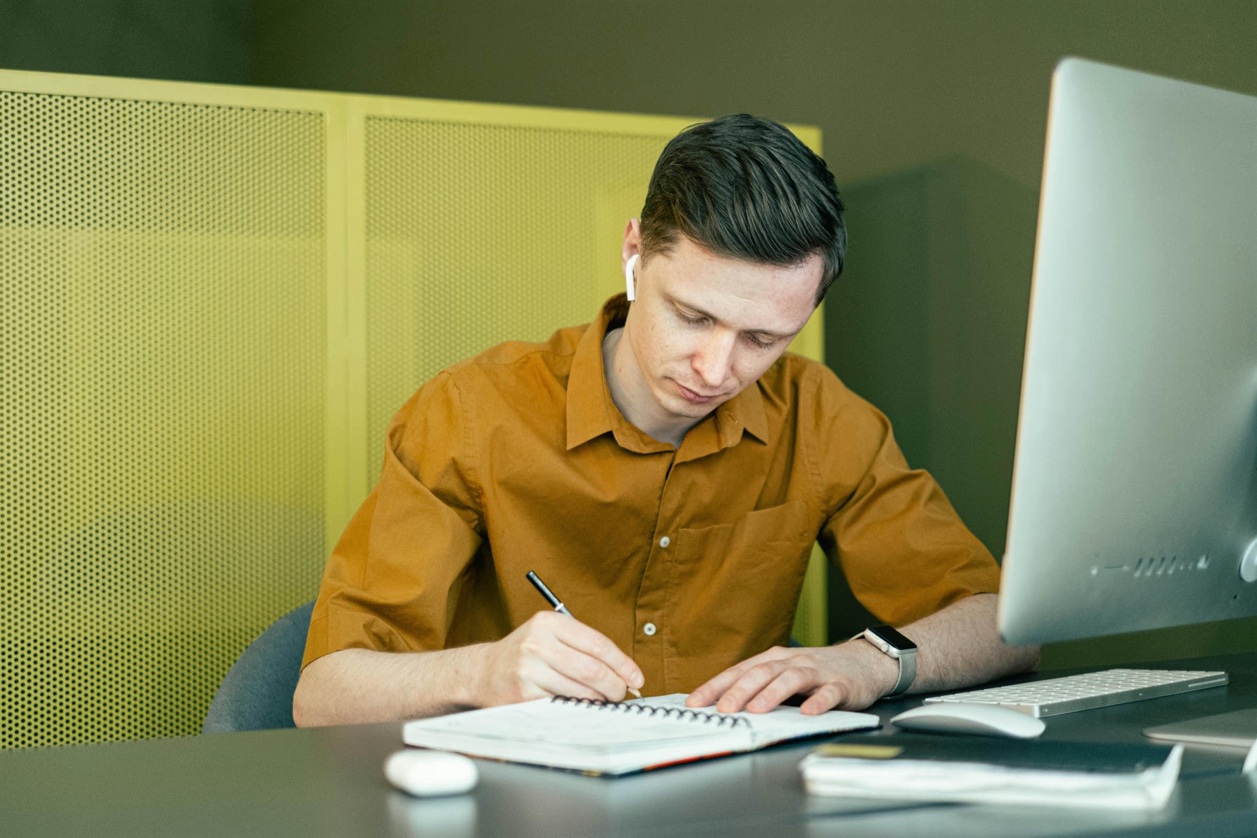 A man seriously writing on his notebook