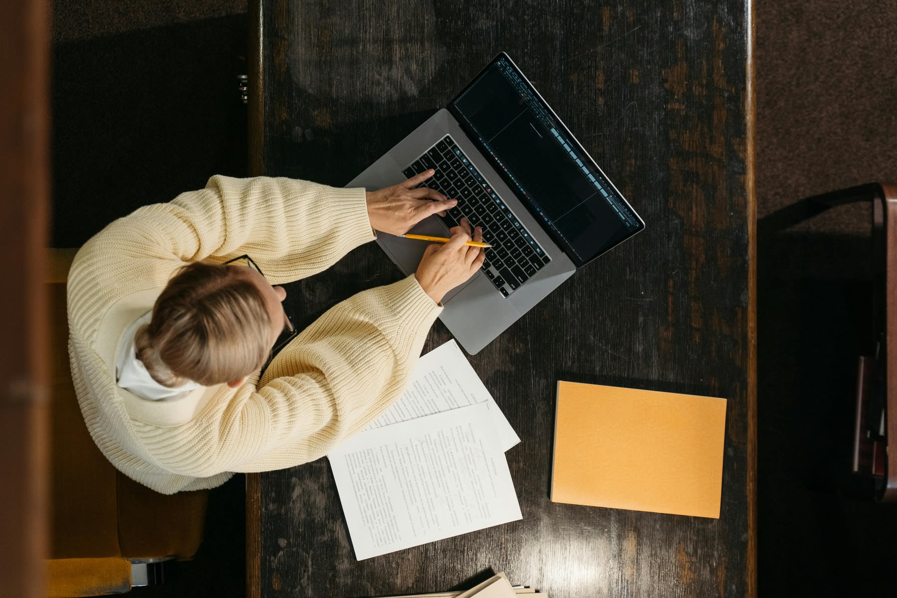 A woman studying online using her laptop and some notebooks 