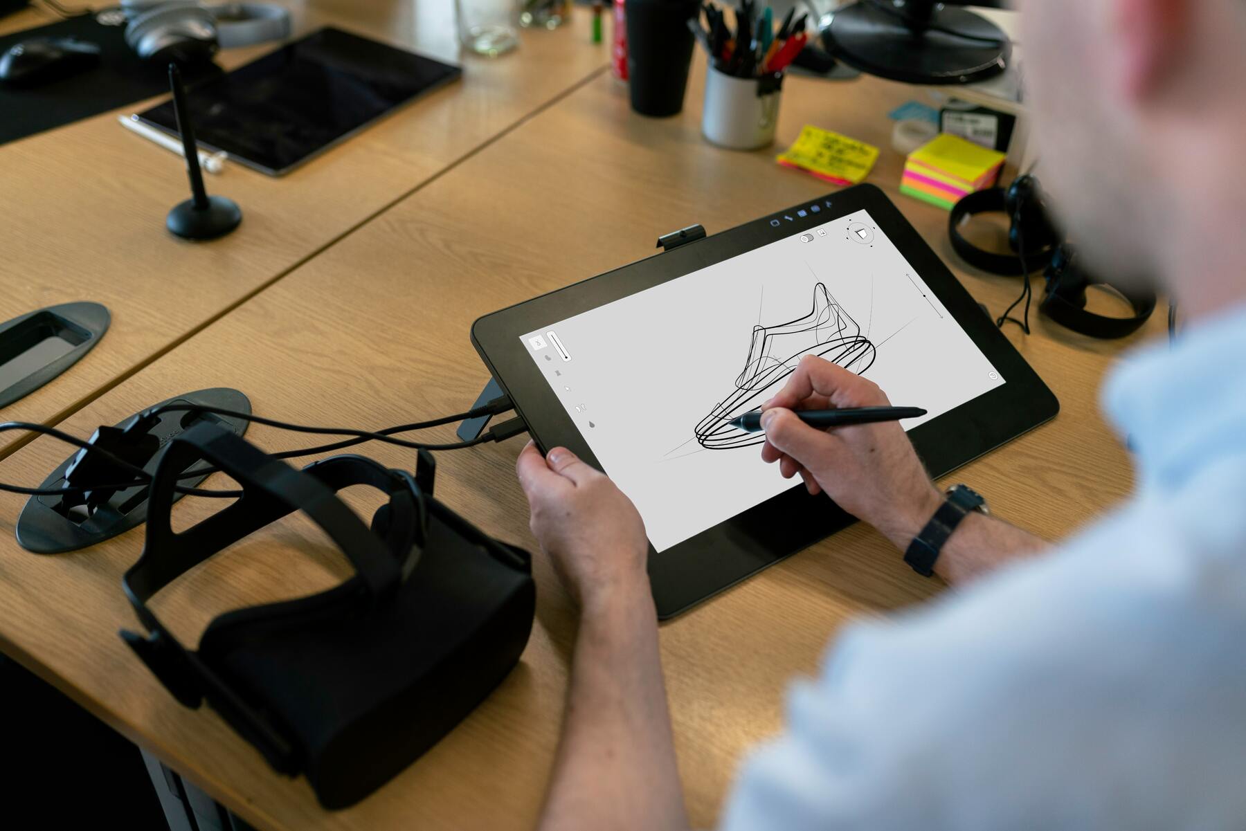 Man drawing a design with a black pen on a tablet