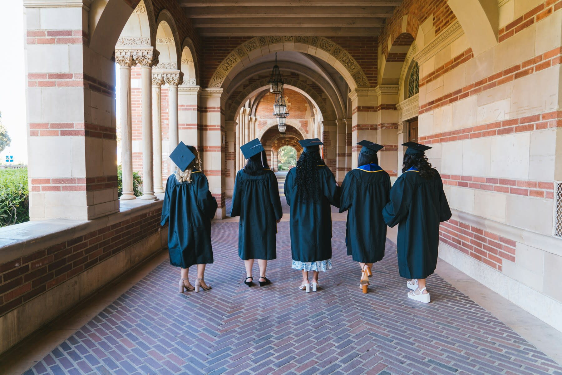 Students wearing their graduation gowns and caps walking around their campus before their graduation ceremony