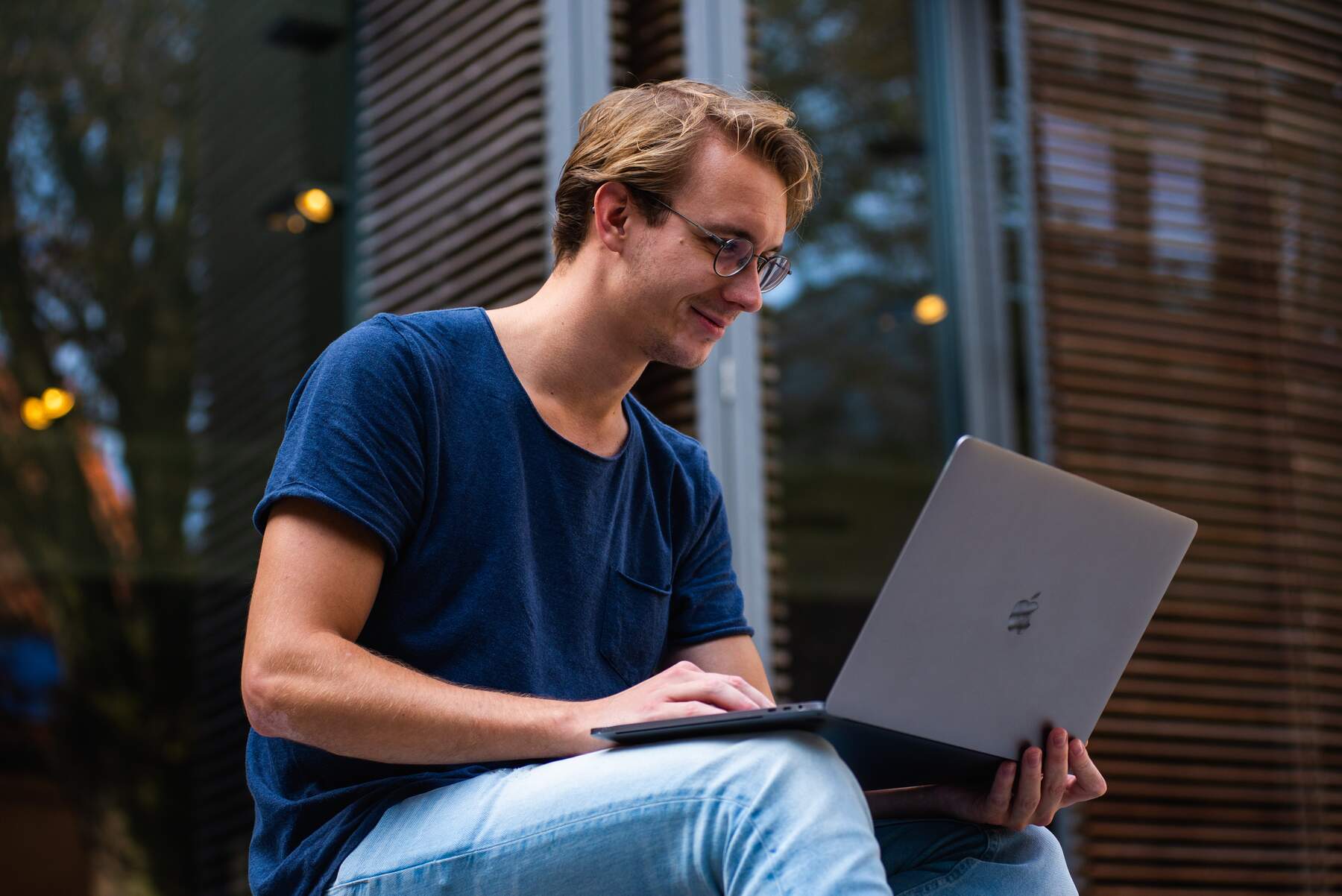 Man sitting outdoors while using his laptop