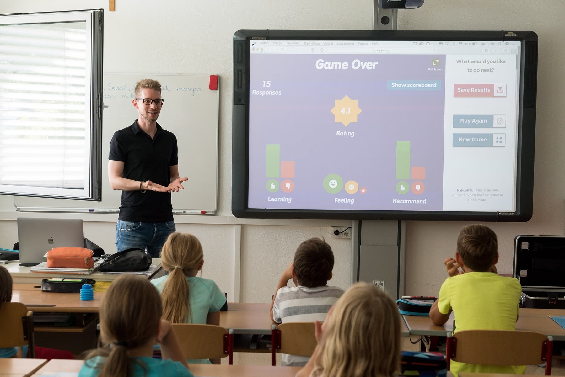 Male teacher utilizing an interactive screen for his young students