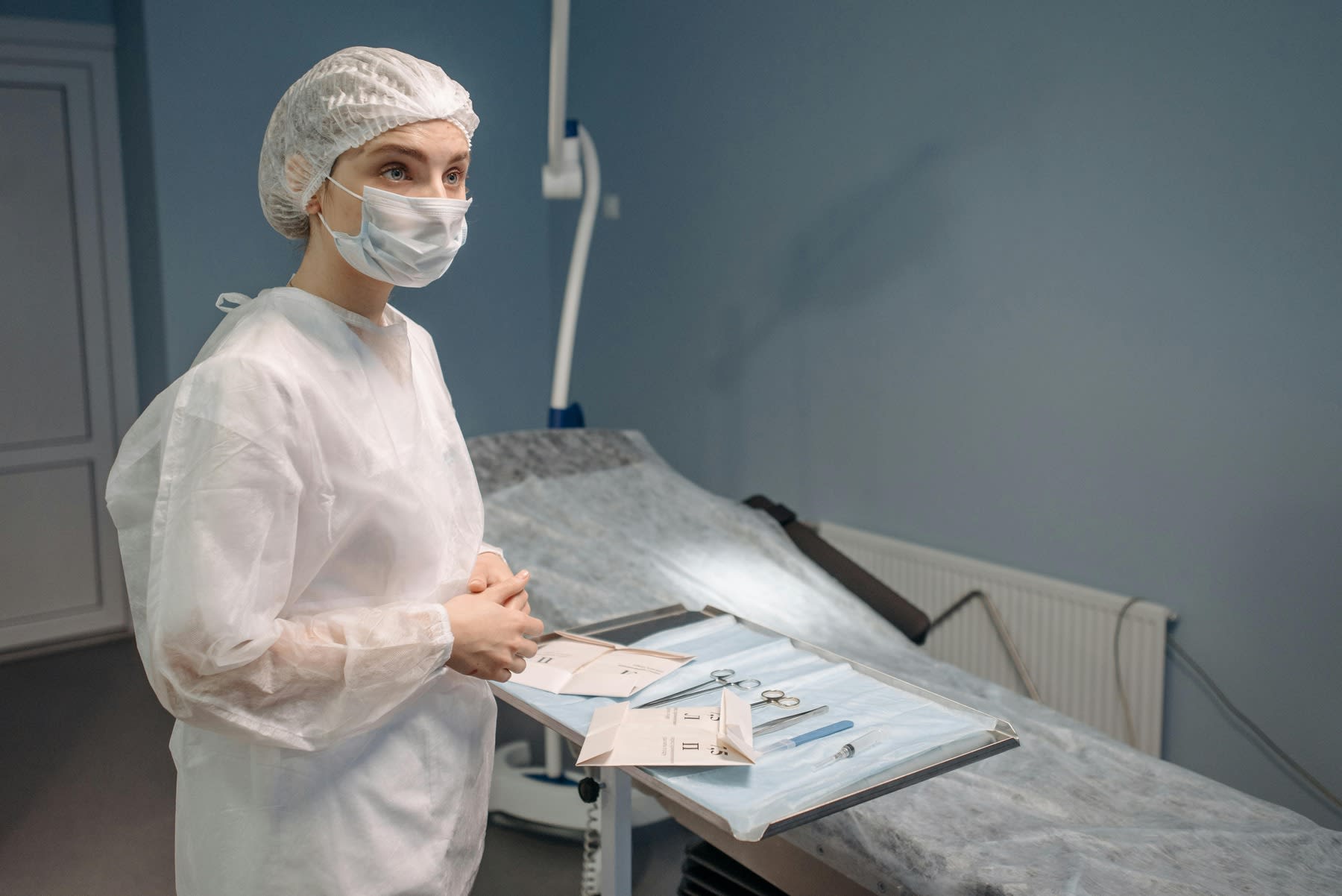 Nurse wearing protective uniform while preparing for a surgery