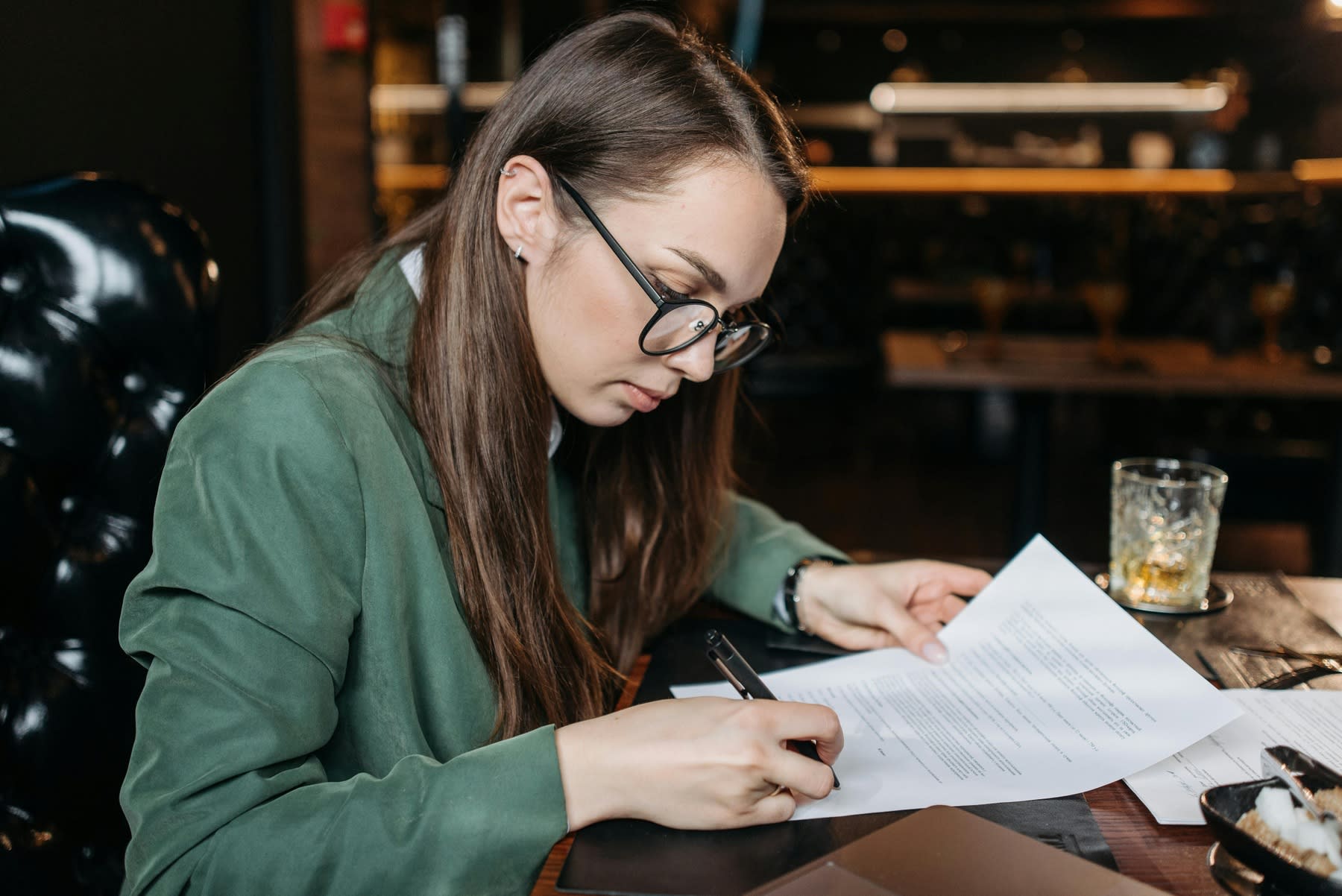 Young woman signing a printed letter