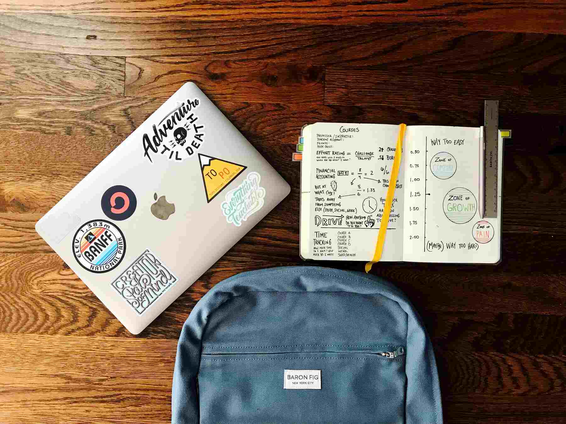 Opened notebook, laptop, and backpack on a table
