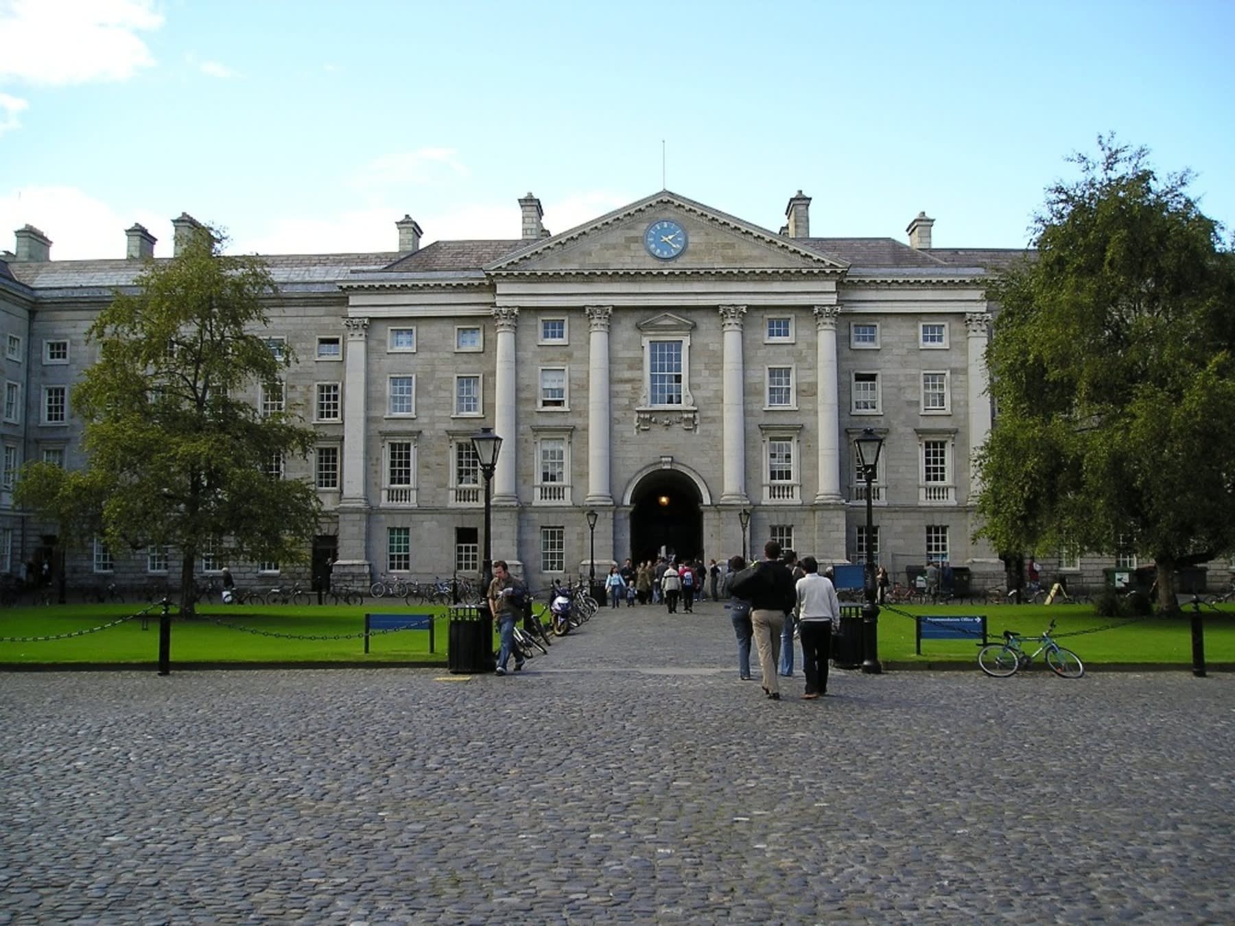 Various students walking into a college campus building