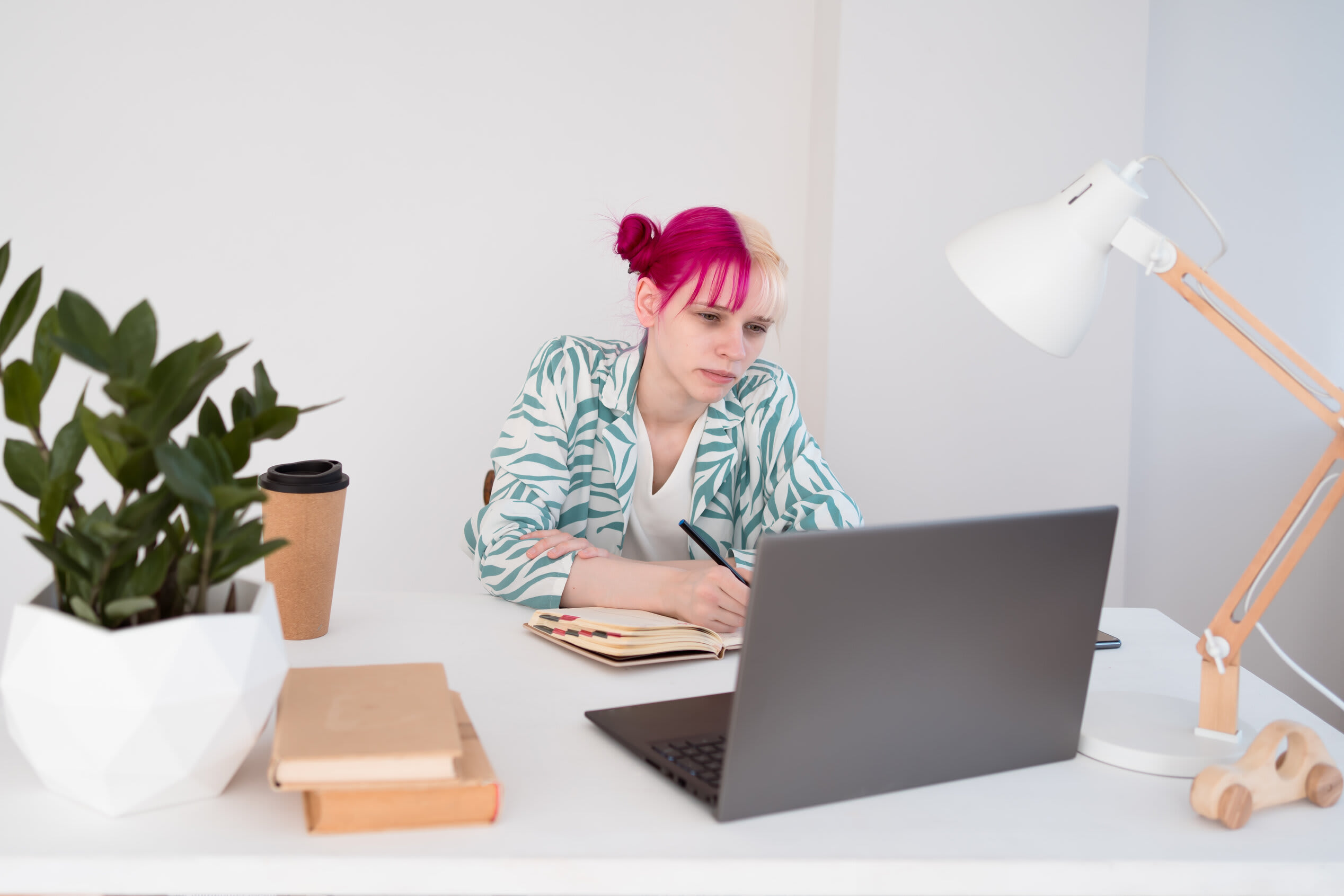 Female student with pink and white hair studying online
