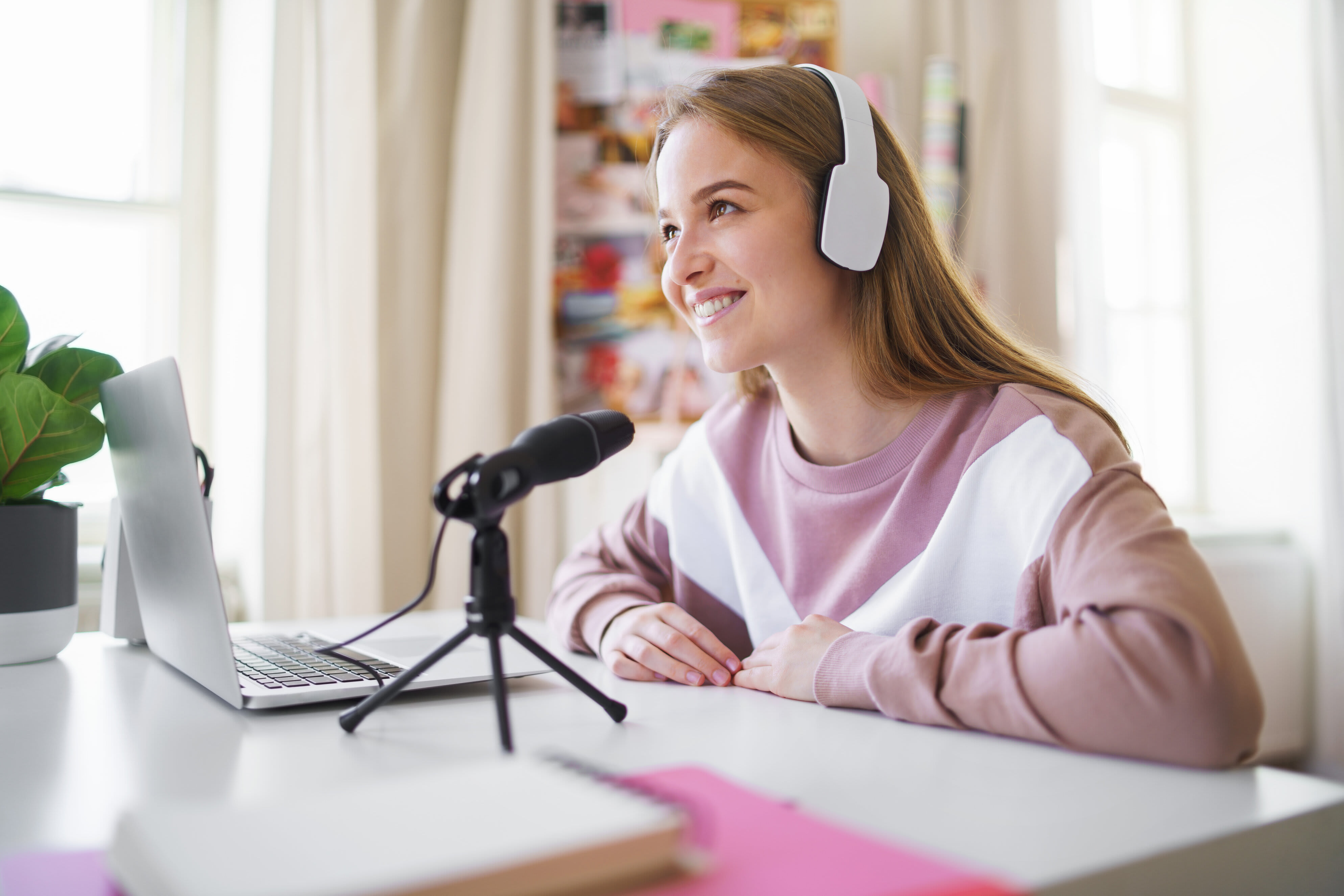 Smiling female student with a microphone and laptop