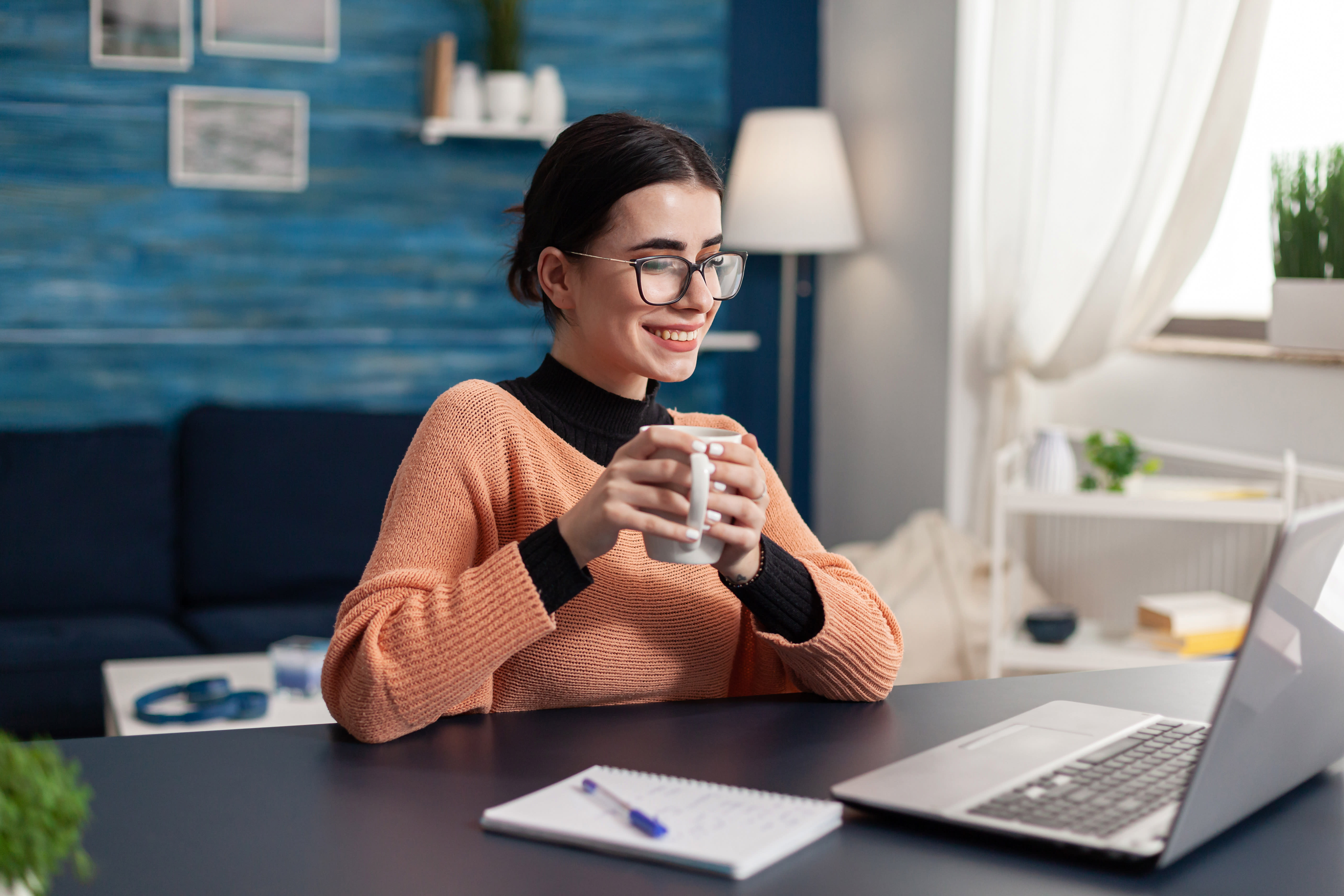 Happy woman with glasses and coffee working from home