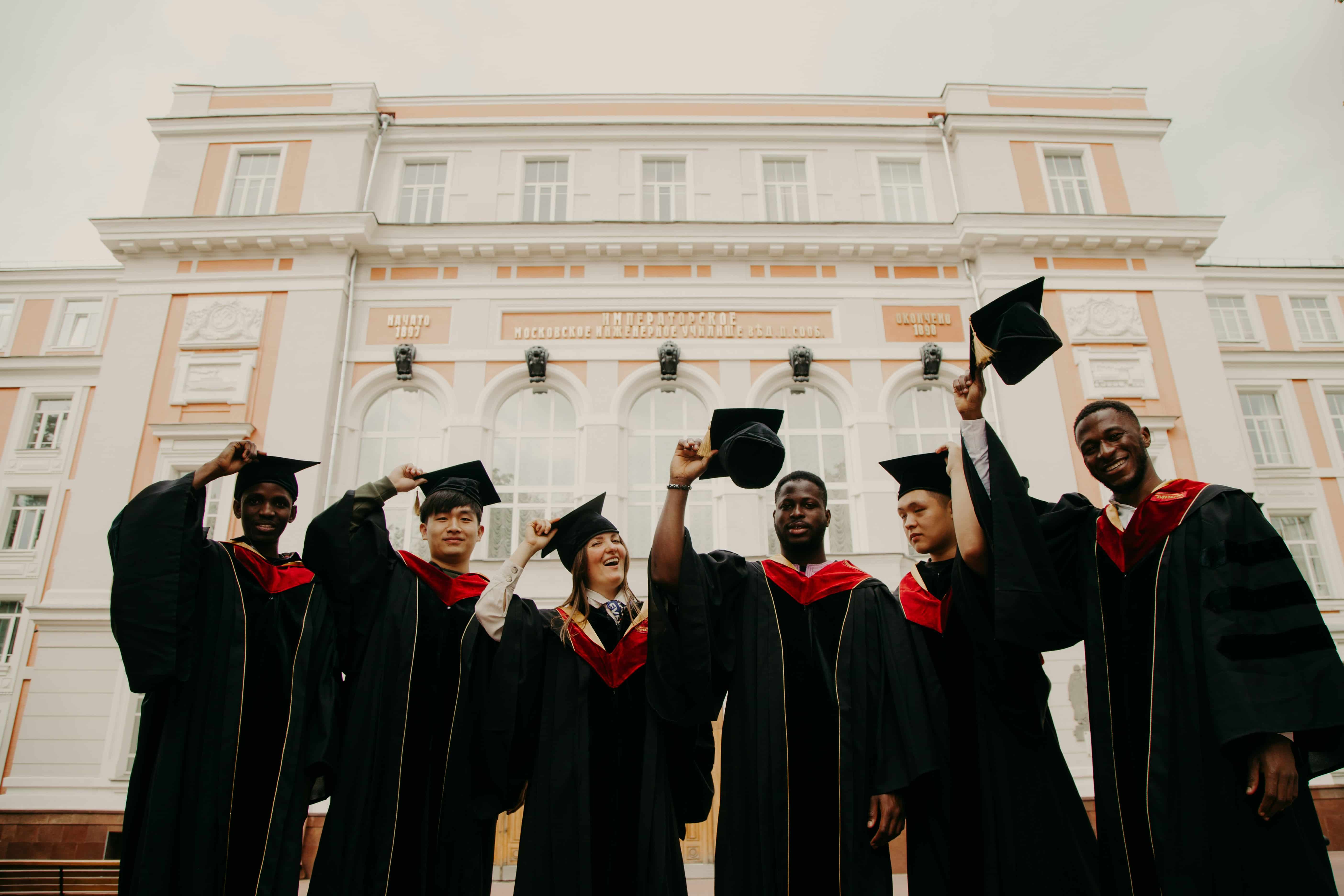 Students wearing their graduation robes and holding their graduation caps