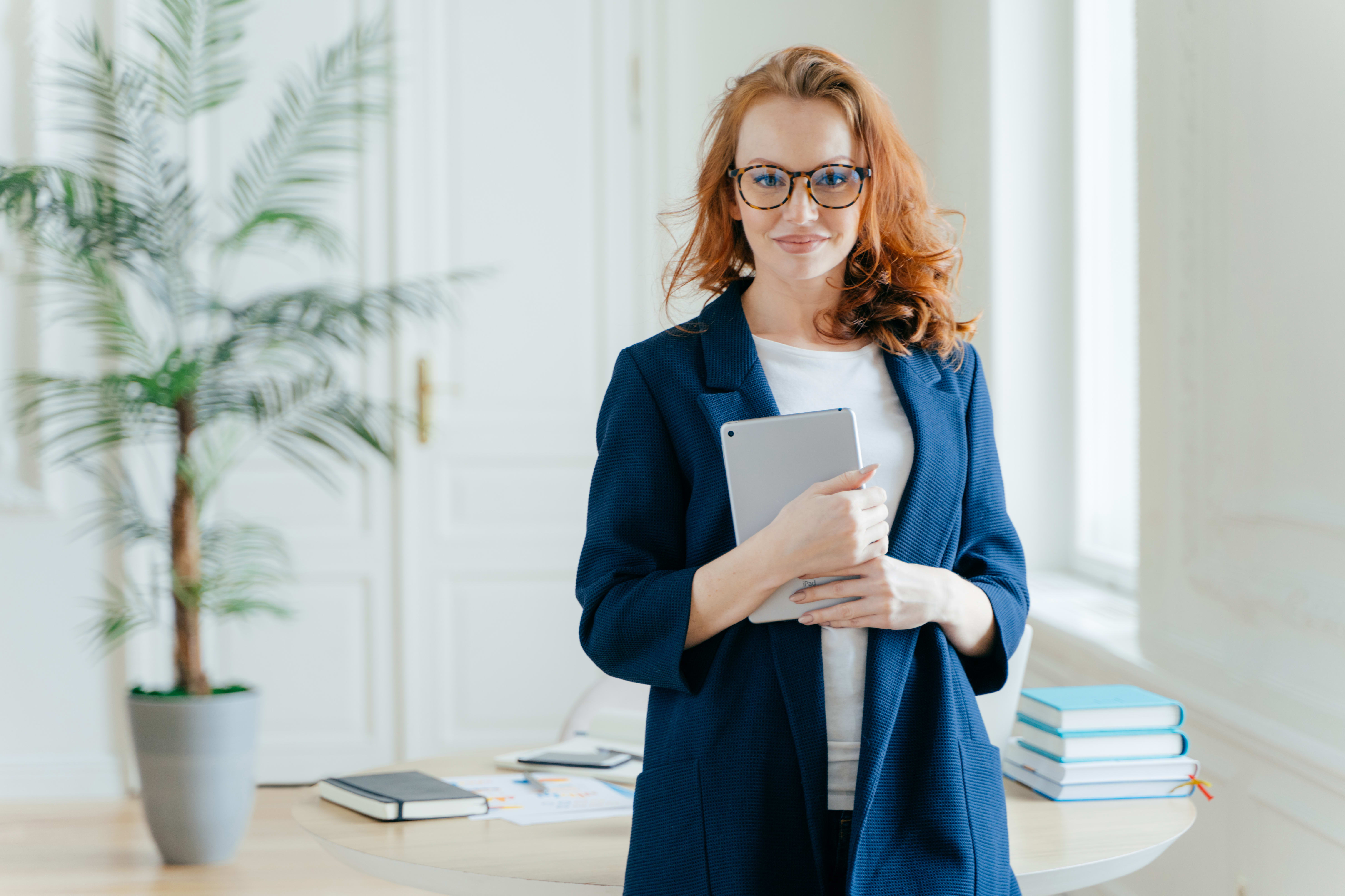 Woman with red hair holding an electronic tablet