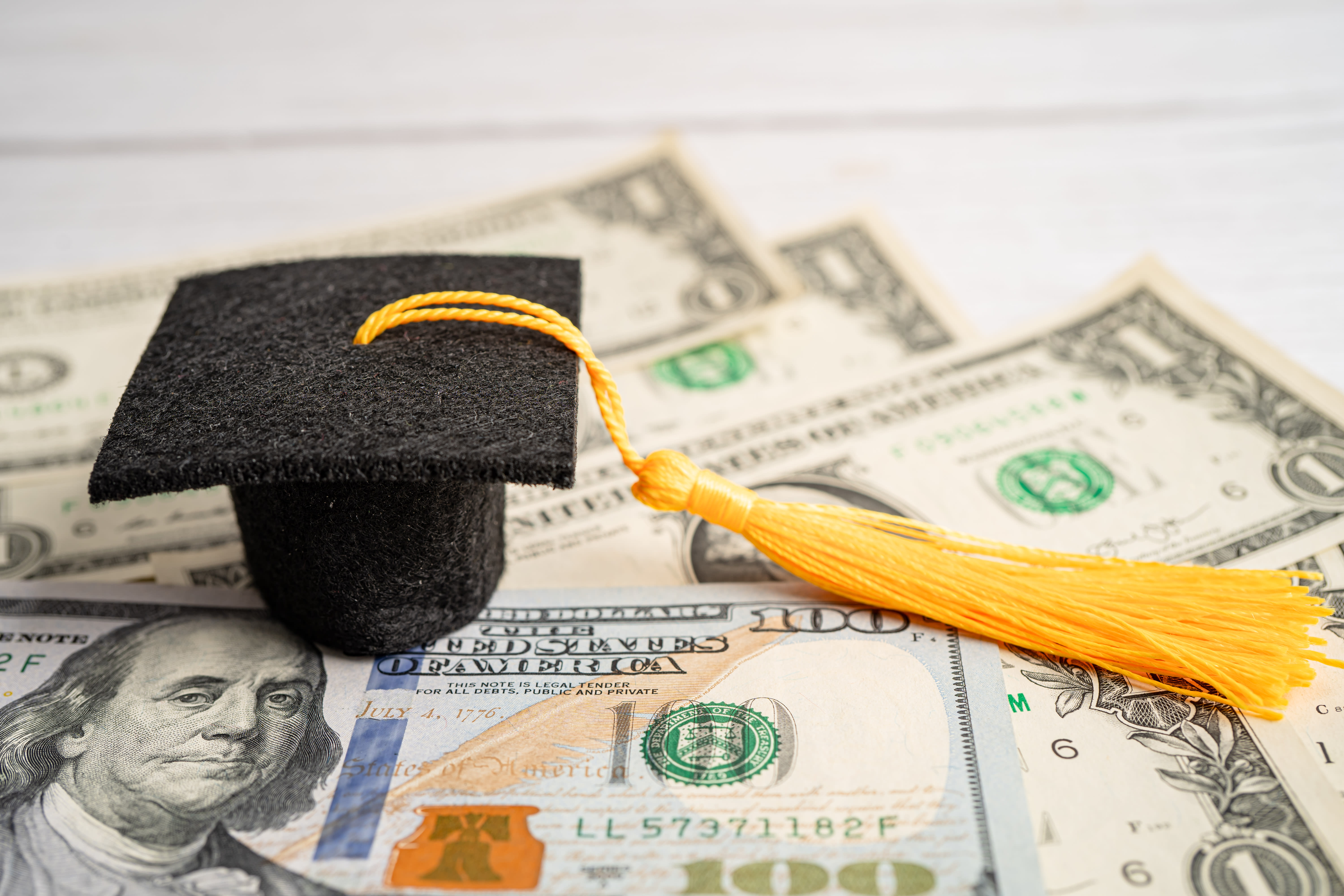 Small graduation cap on U.S. dollars
