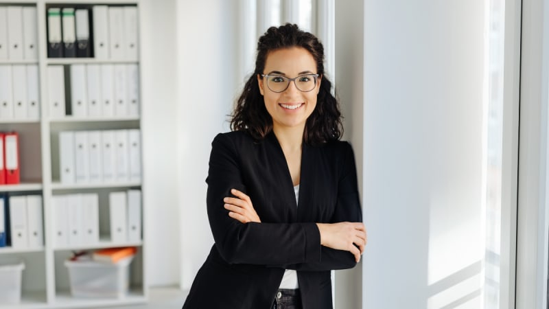 Woman smiling with arms folded in an office