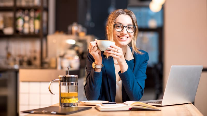 Woman drinking coffee at a desk