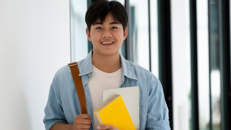 Happy student with yellow notebook