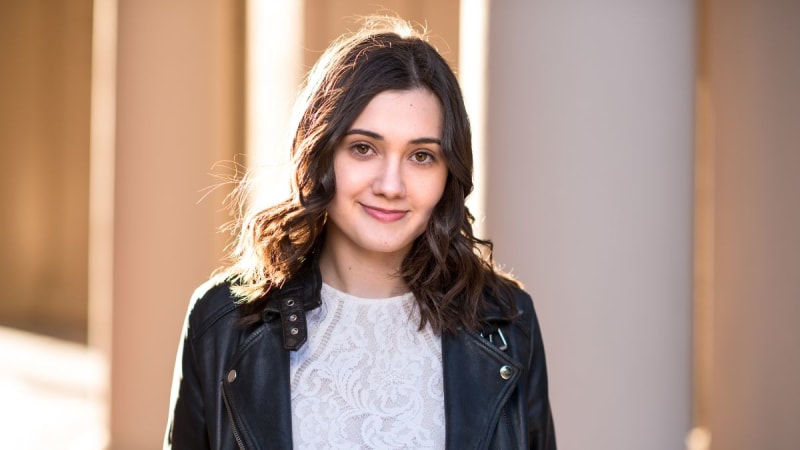 Woman smiling in front of a column