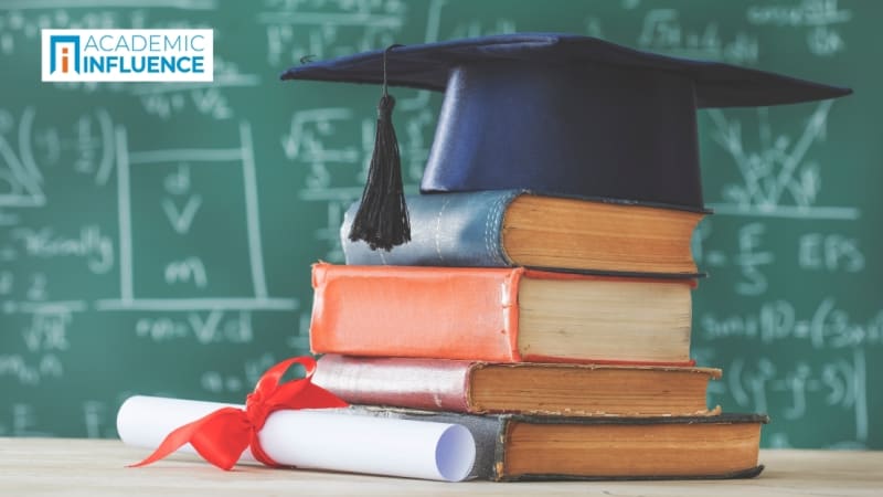 Stack of books with a graduation cap