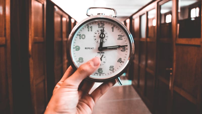 Hand holding a clock in the library