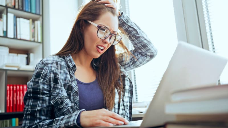 Woman thinking next to a laptop