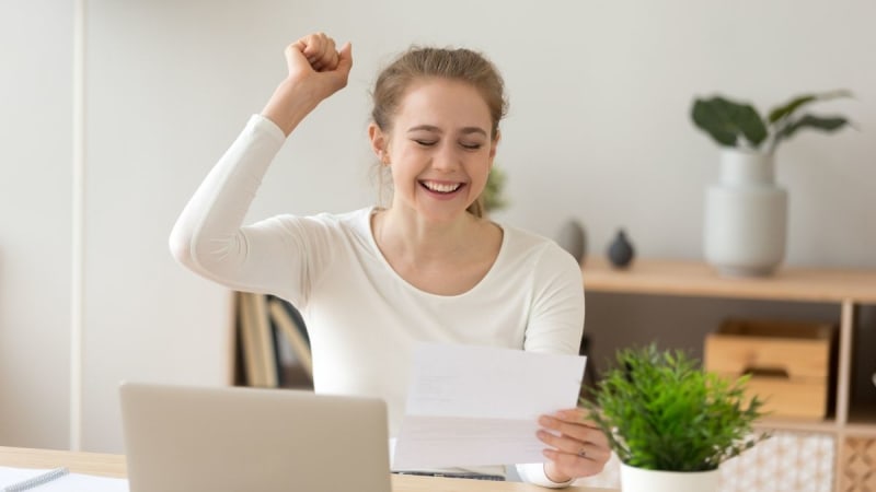 Happy woman celebrating at her desk