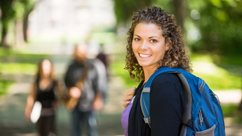 Woman smiling outside on a college campus
