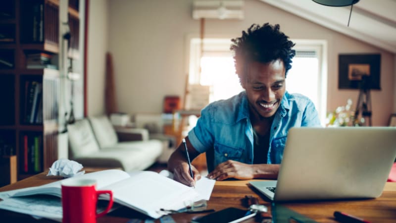 Happy male student working from home