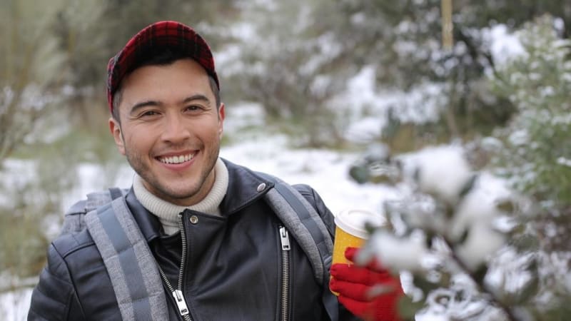 Happy male student outside in winter