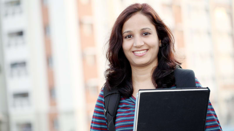 Woman smiling with a black notebook