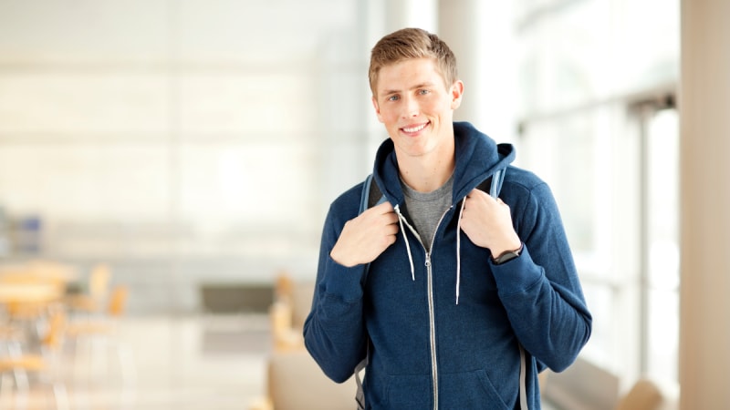 Happy male student with a backpack