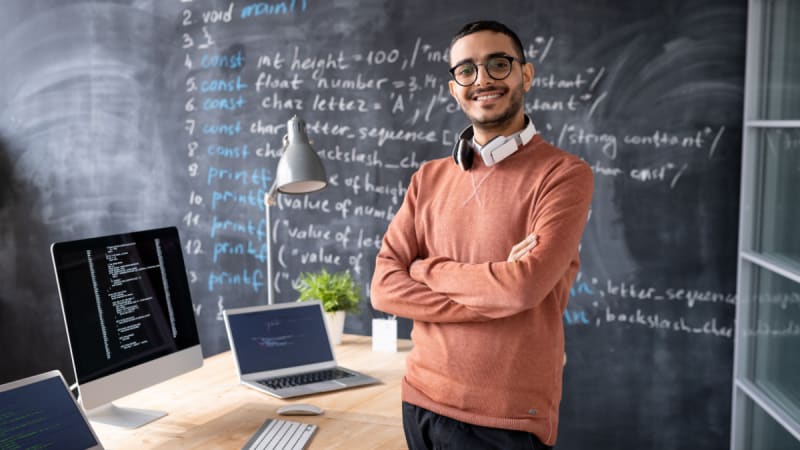 Man standing in front of a blackboard