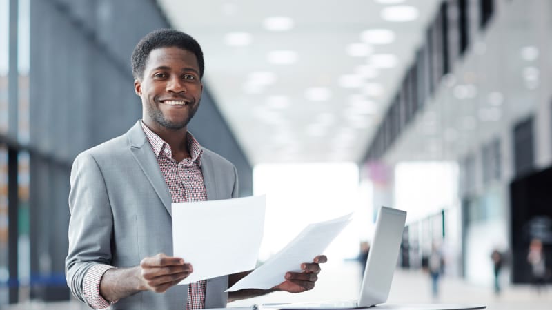 Man holding paper inside a building